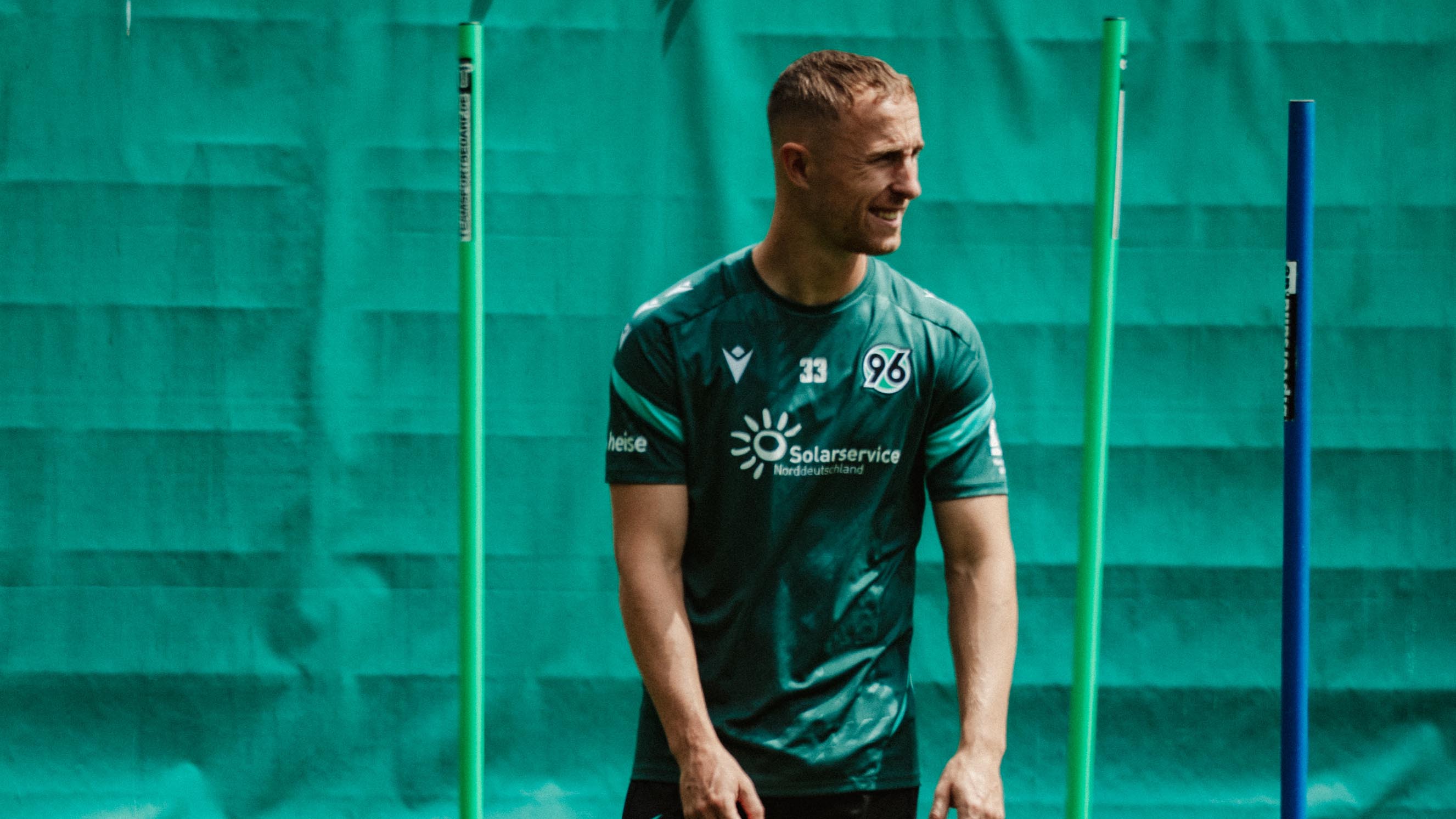 Maurice Neubauer steht im Training mit Ball am Hütchen.