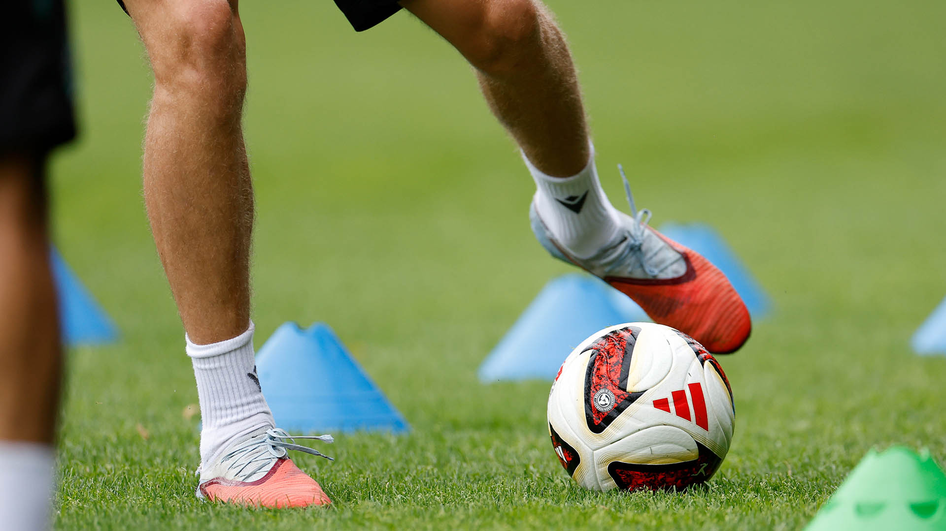 Ein Spieler tritt gegen den neuen Adidas-Ball, es sind nur die Beine zu sehen. 