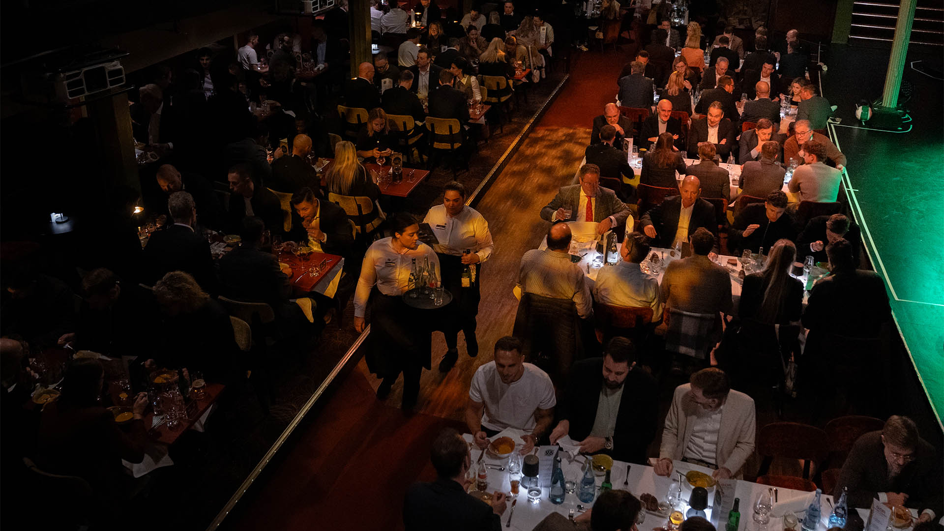 Blick von oben ins GOP, in dem Menschen an Zehner-Tischen sitzen und essen.