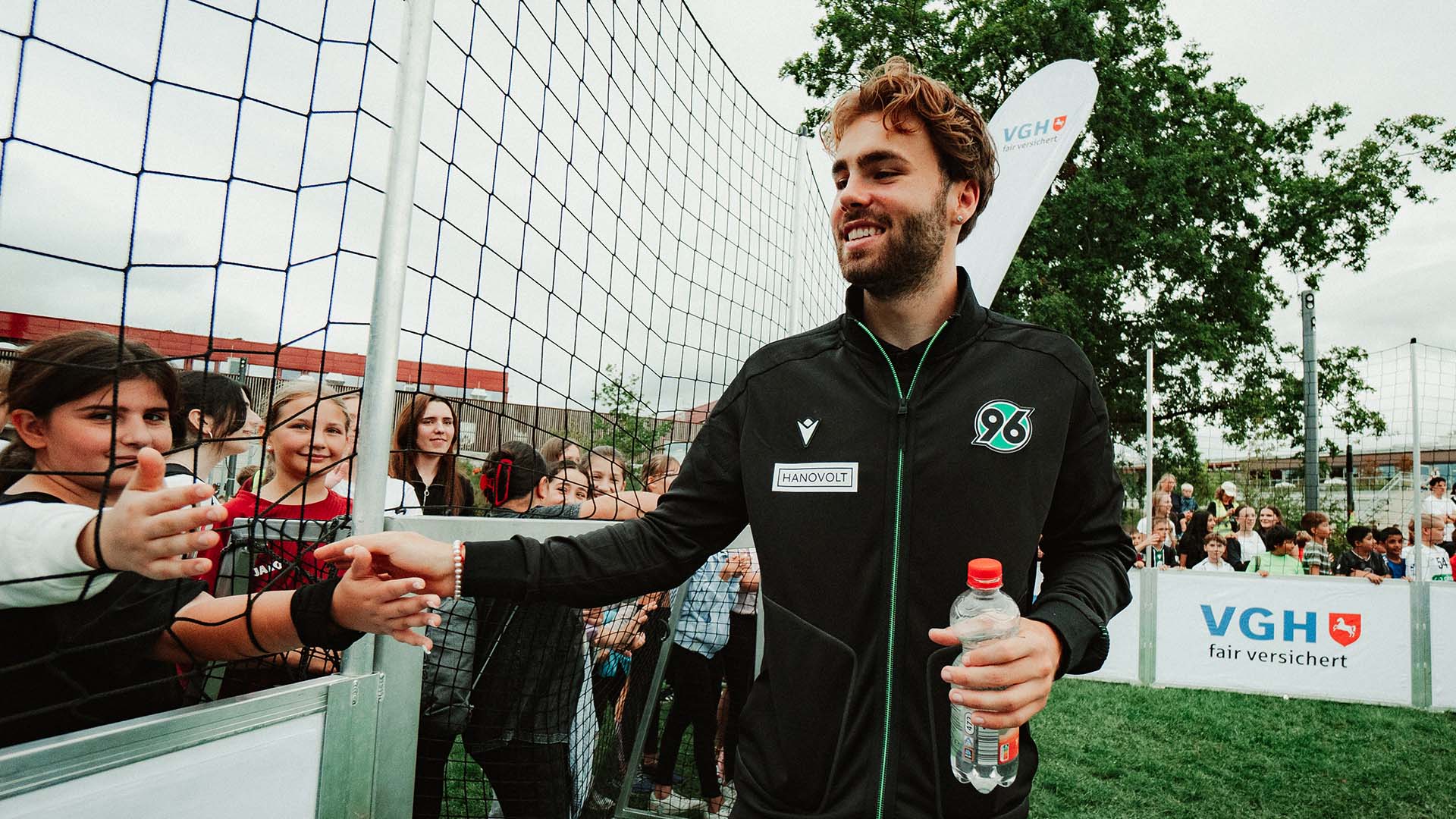 Kolja Oudenne, der Kinder abklatscht