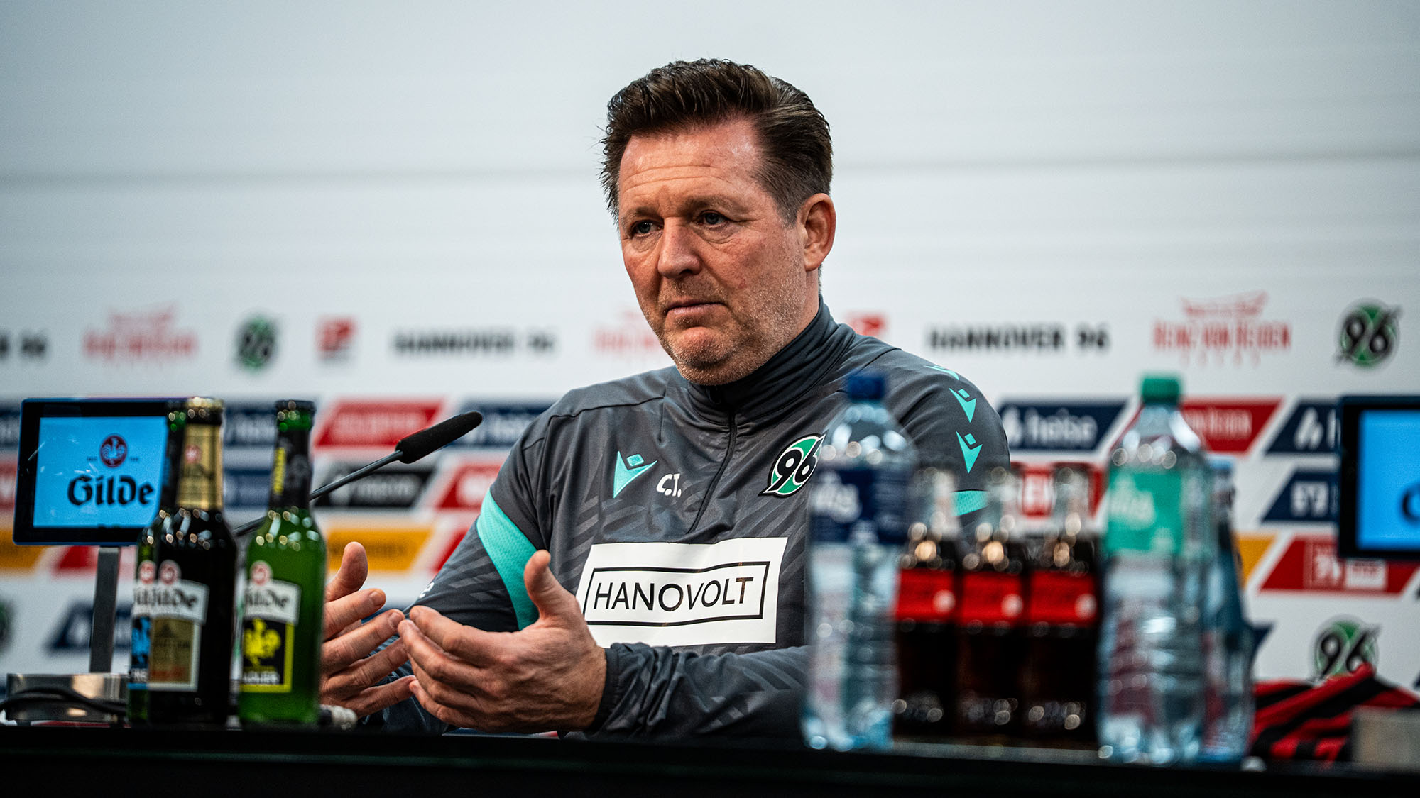 Christian Titz sitzt auf dem Pressekonferenzpodium.