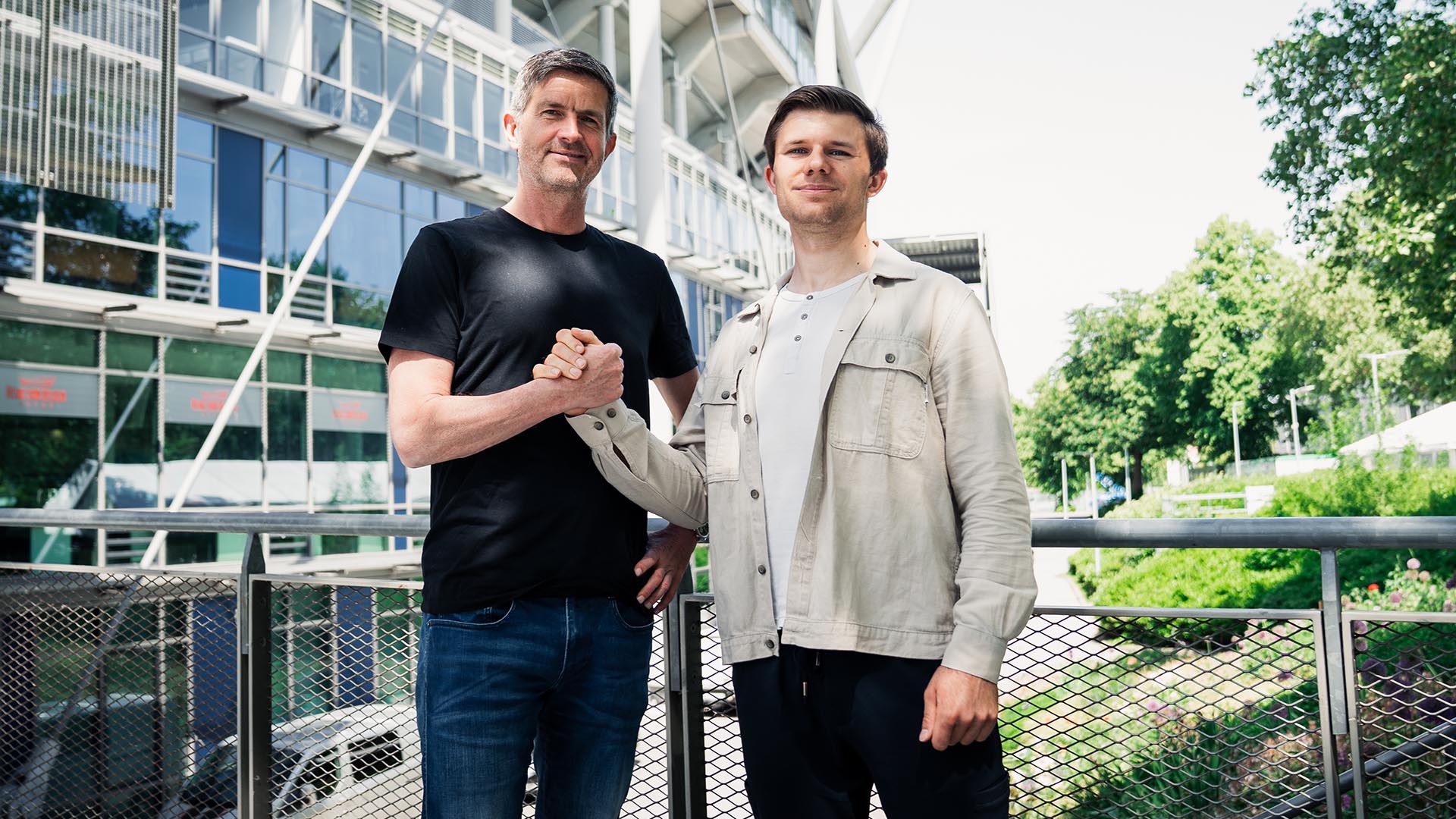 Zwei Männer beim Handshake vor der Heinz von Heiden Arena.