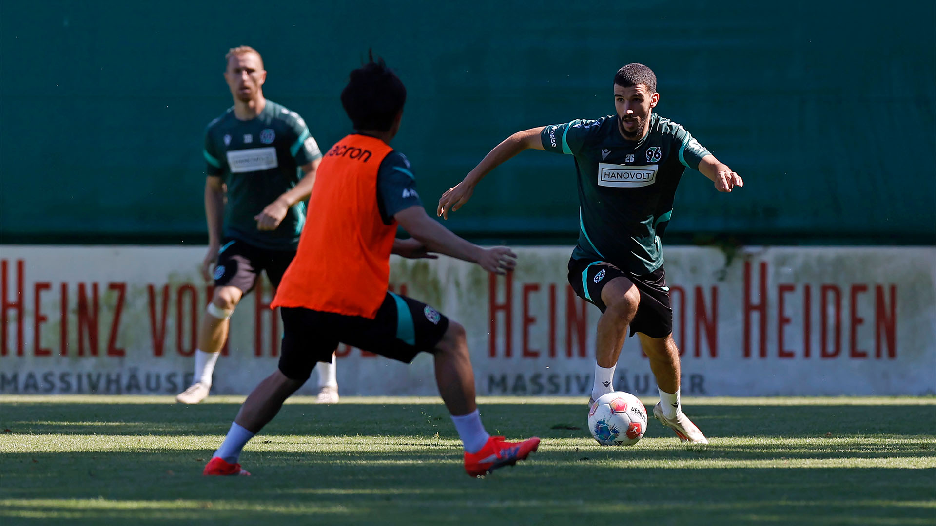 Waniss Taibi von vorne am Ball, läuft auf Daisuke Yokota (von hinten zu sehen) zu.