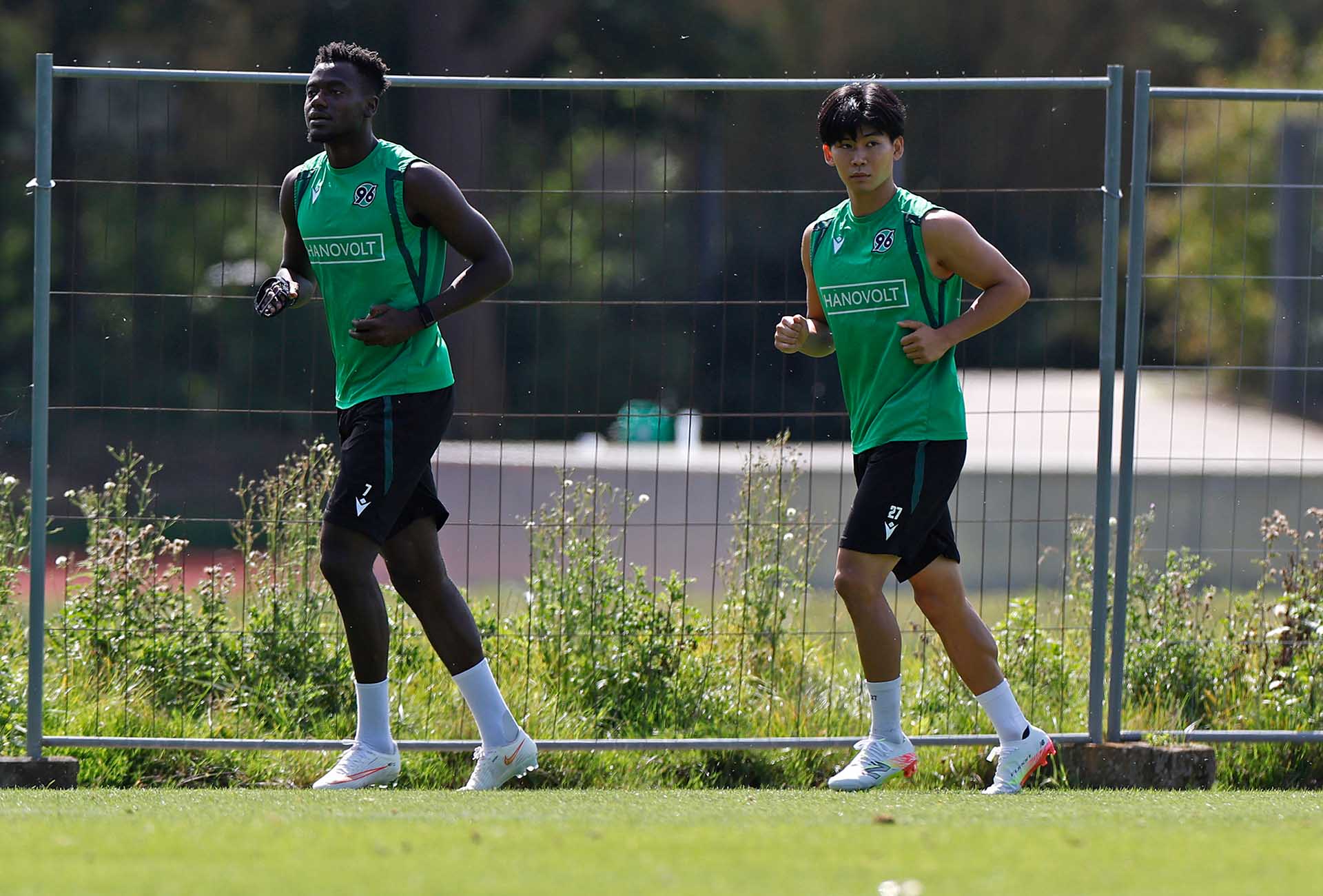 Die 96-Spieler Mustapha Bundu und Hayate Matsuda drehen eine Laufrunde auf dem Trainingsplatz. 