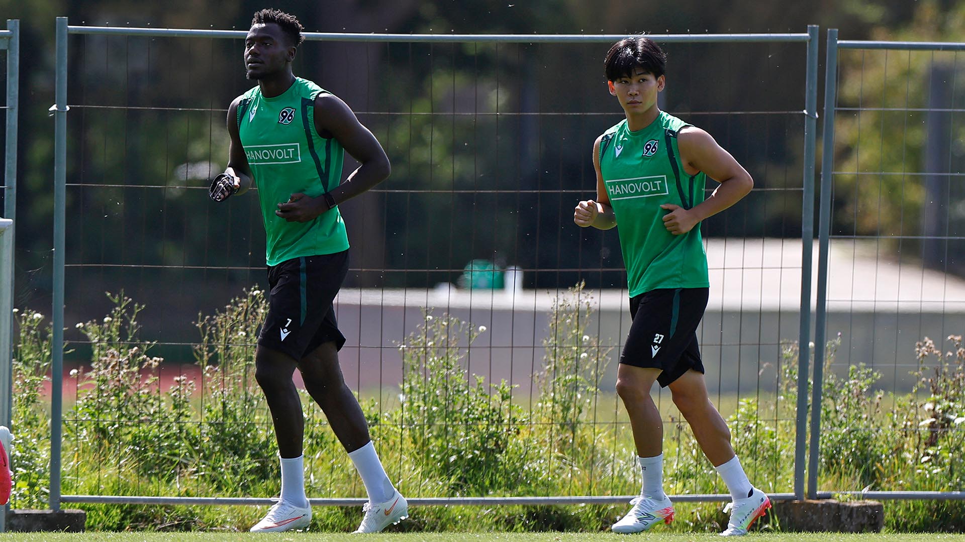 Die 96-Spieler Mustapha Bundu und Hayate Matsuda drehen eine Laufrunde auf dem Trainingsplatz. 
