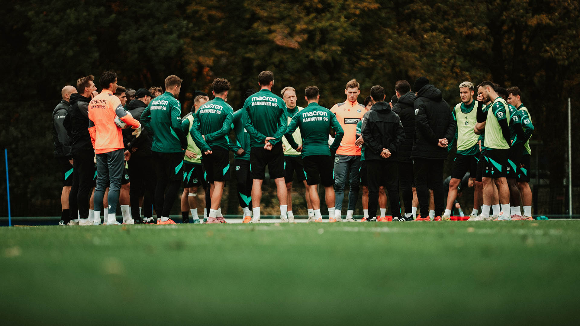 Die Mannschaft steht in einem Kreis auf dem Trainingsplatz. 