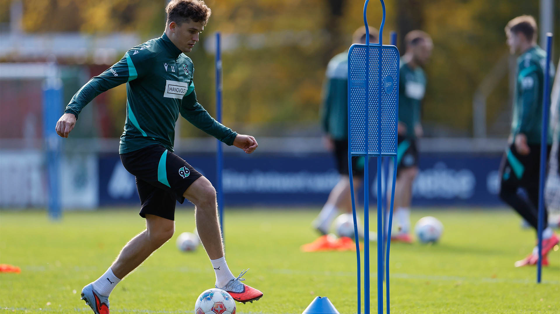 Seitliche Ganzkörperaufnahme von Benedikt Pichler am Ball im Training.