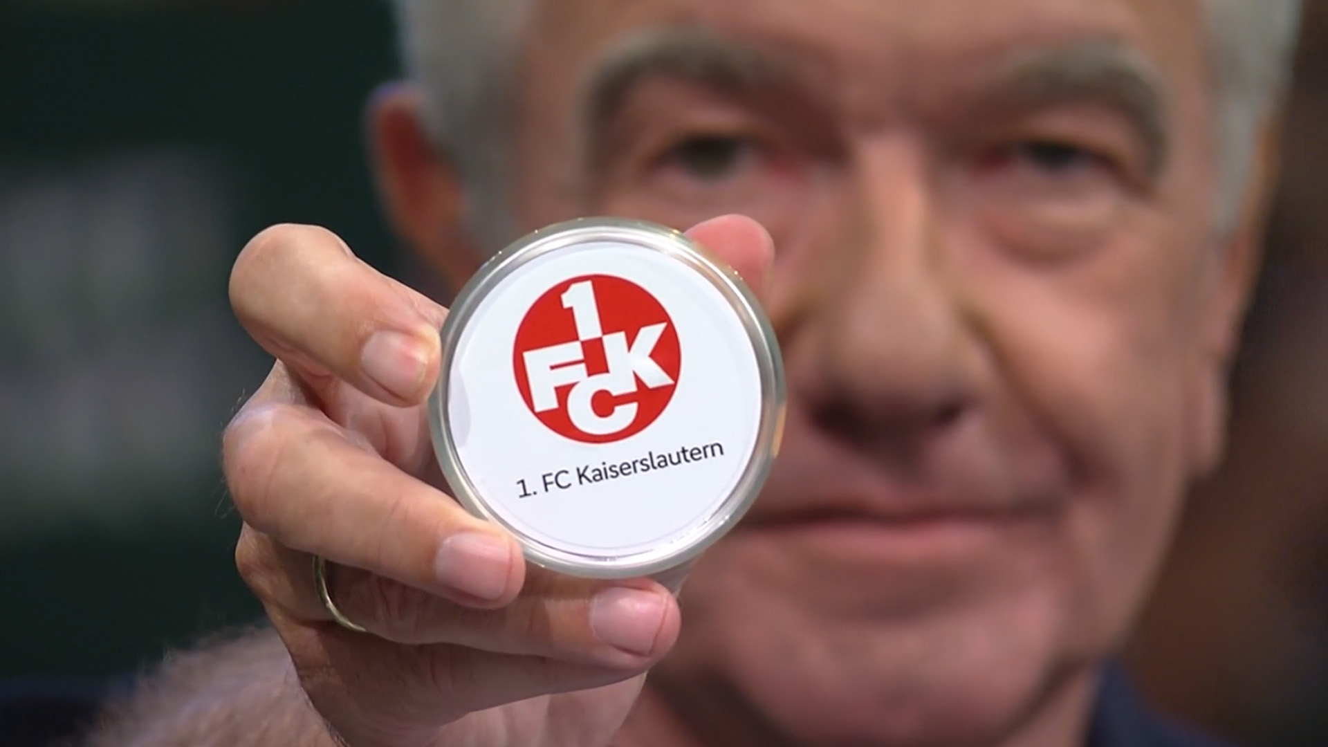 Die Kugel mit dem FCK-Logo wird in die Kamera gehalten.