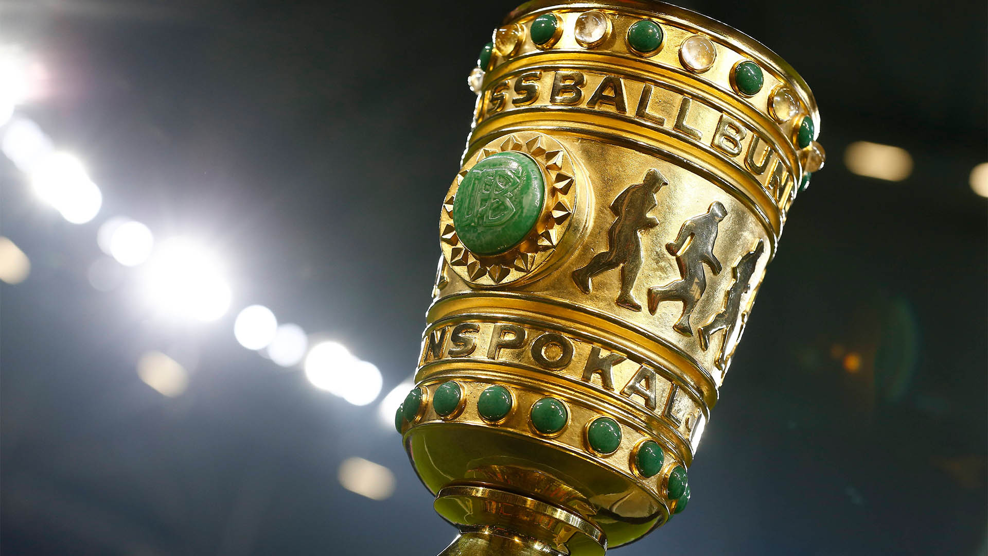 Der DFB-Pokal mit Flutlicht im Hintergrund.