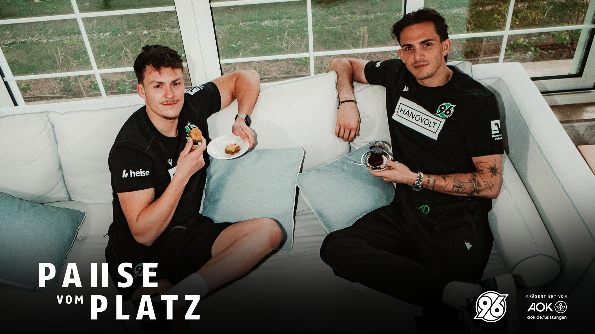 Niklas und Nahuel Noll sitzen auf dem Sofa, mit Baklava und Chai in der Hand.
