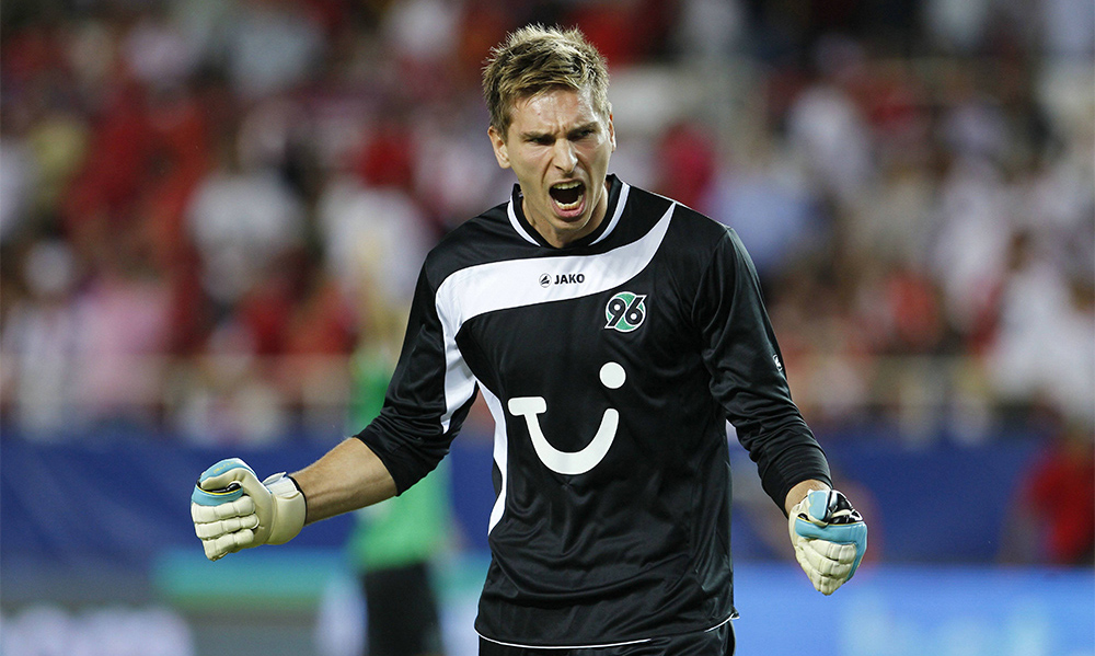 Ron-Robert Zieler im schwarzen Torwarttrikot ballt die Fäuste und stößt einen Jubelschrei aus. 