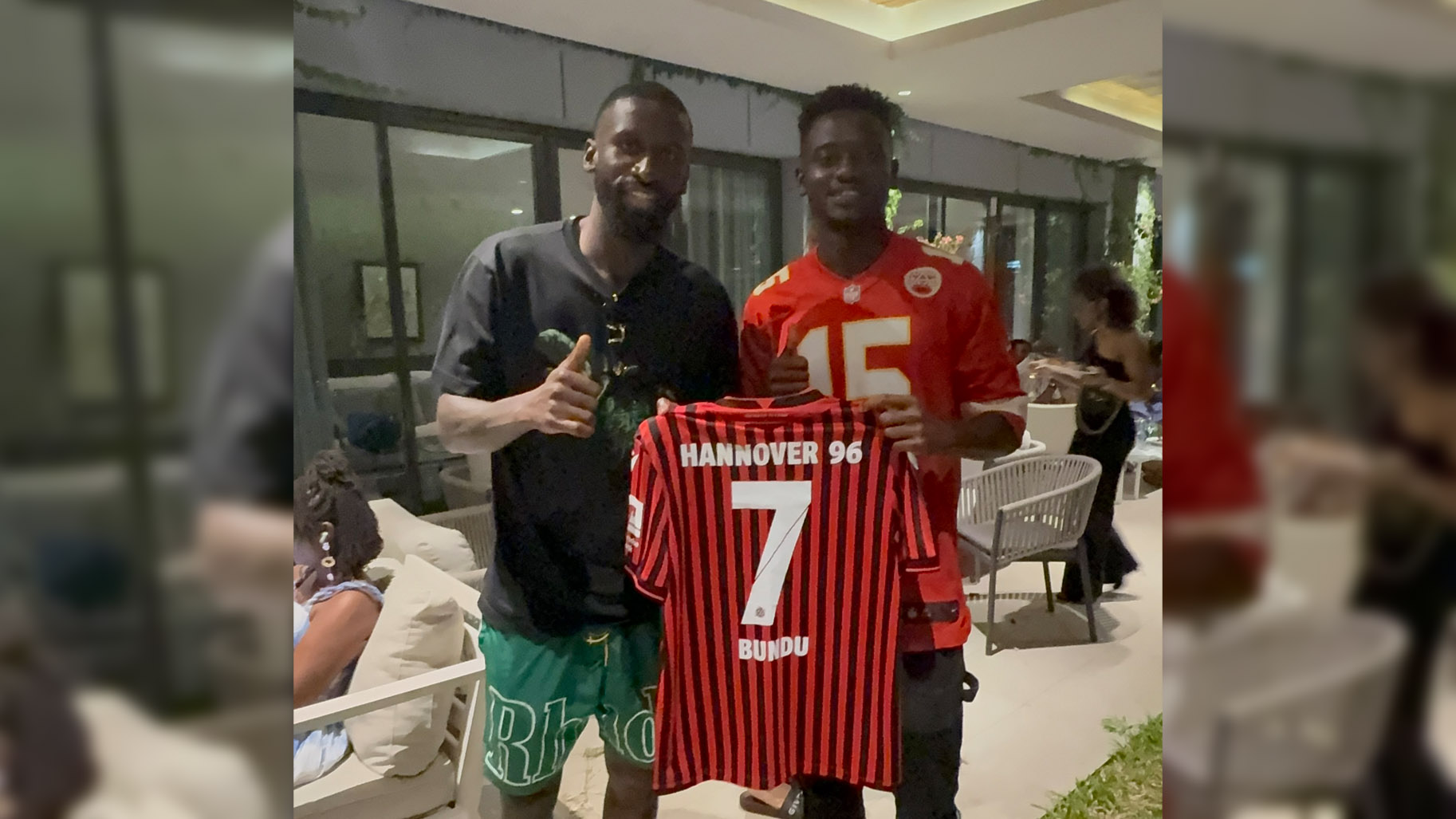 Antonio Rüdiger (links) und Mustapha Bundu grinsen in die Kamera, beide halten Bundus 96-Trikot.