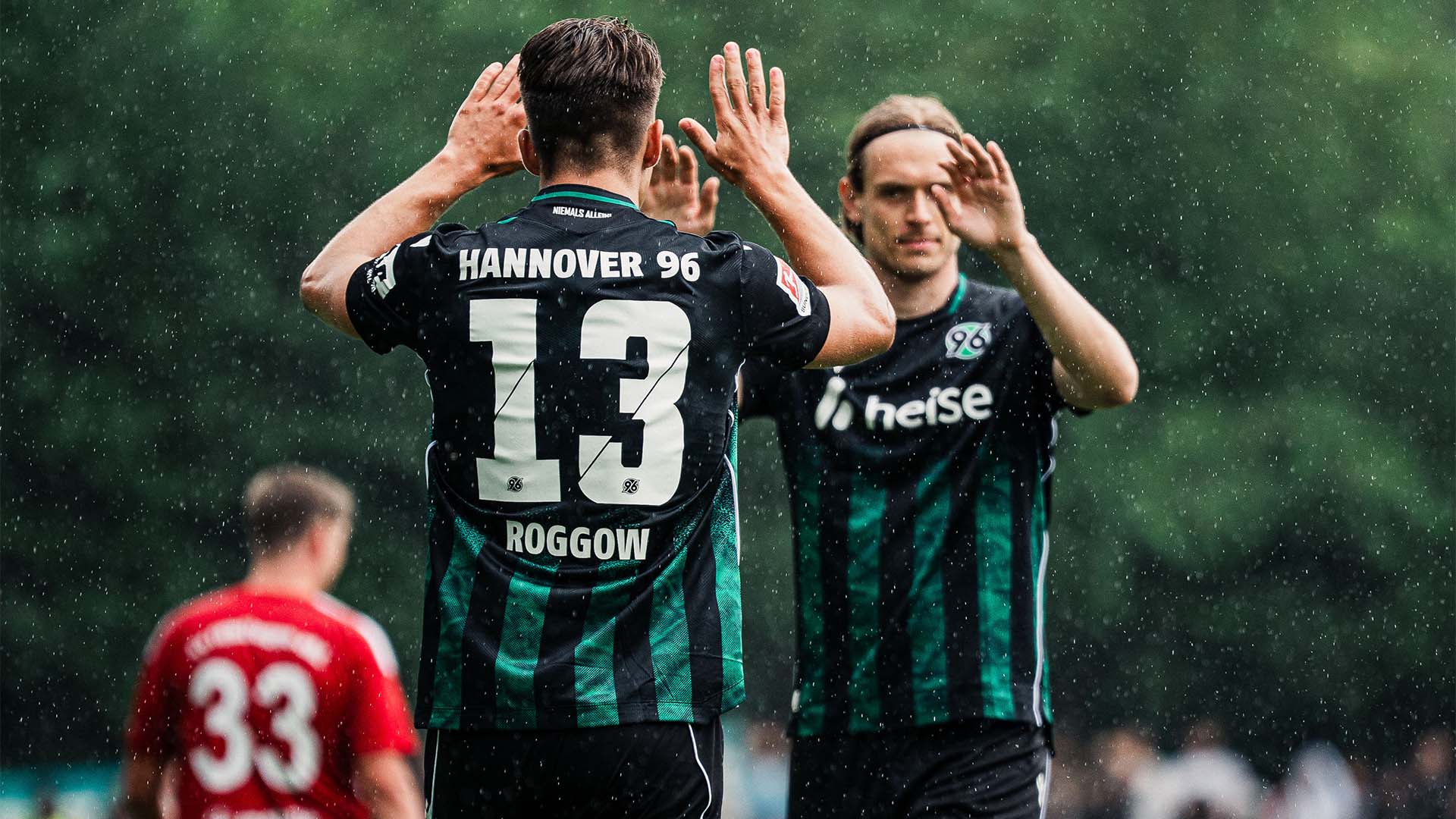 Franz Roggow und Stefan Teitur Thordarson in Auswärtstrikots klatschen miteinander ab. 