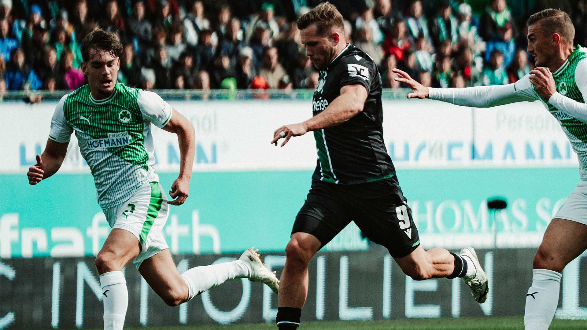 Benjamin Källman im Laufduell mit zwei Fürthern am Ball.