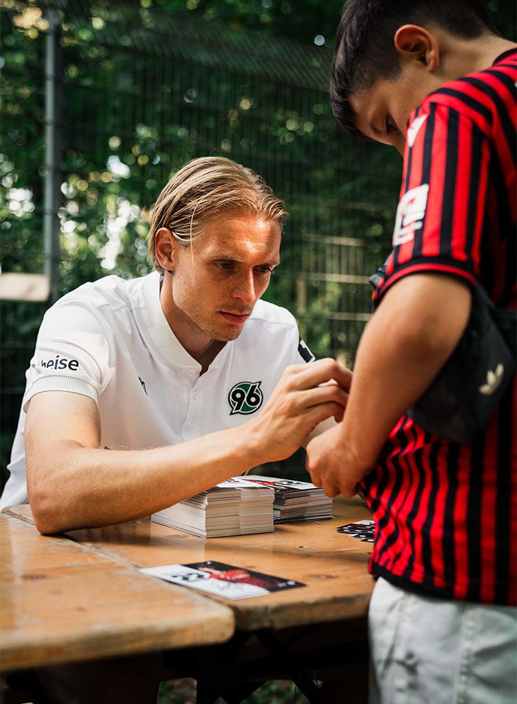 96-Spieler Stefan Thordarson unterschreibt auf einem Trikot.