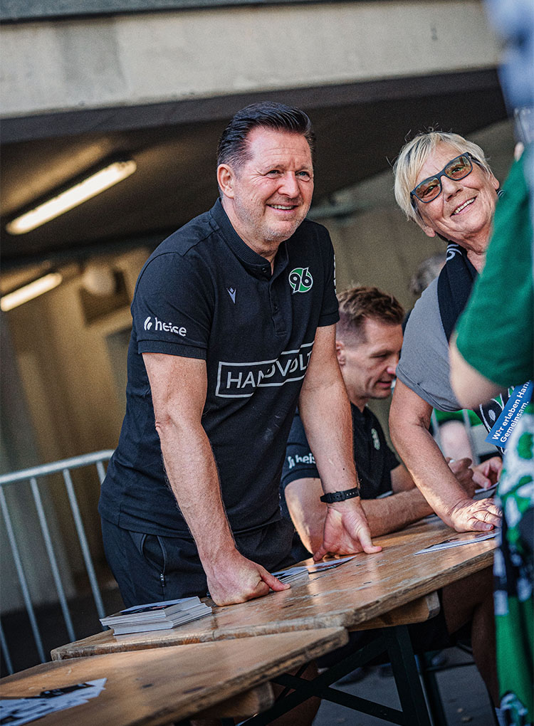 96-Cheftrainer Christian Titz posiert mit einem Fan. 