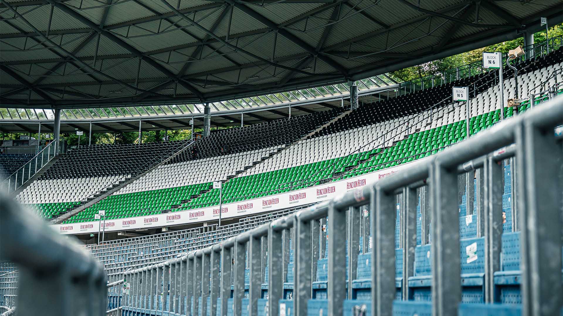 Blick in die Nordkurve der Heinz von Heiden Arena mit schwarz-weiß-grünen Sitzen.