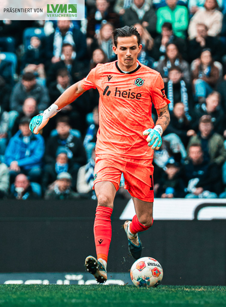 Nahuel Noll im orangefarbenen Torwartoutfit am Ball.