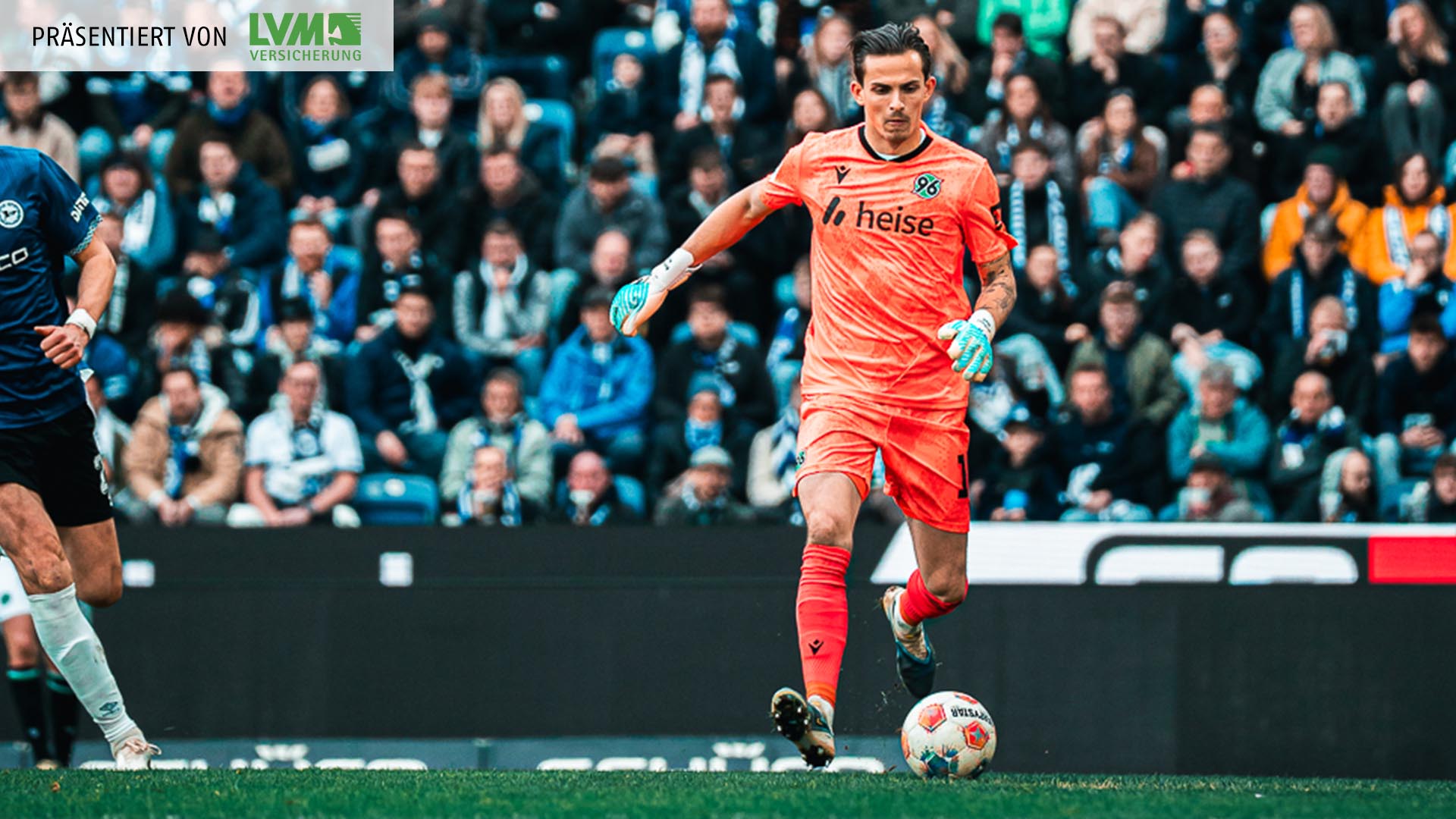 Nahuel Noll im orangefarbenen Torwartoutfit am Ball.