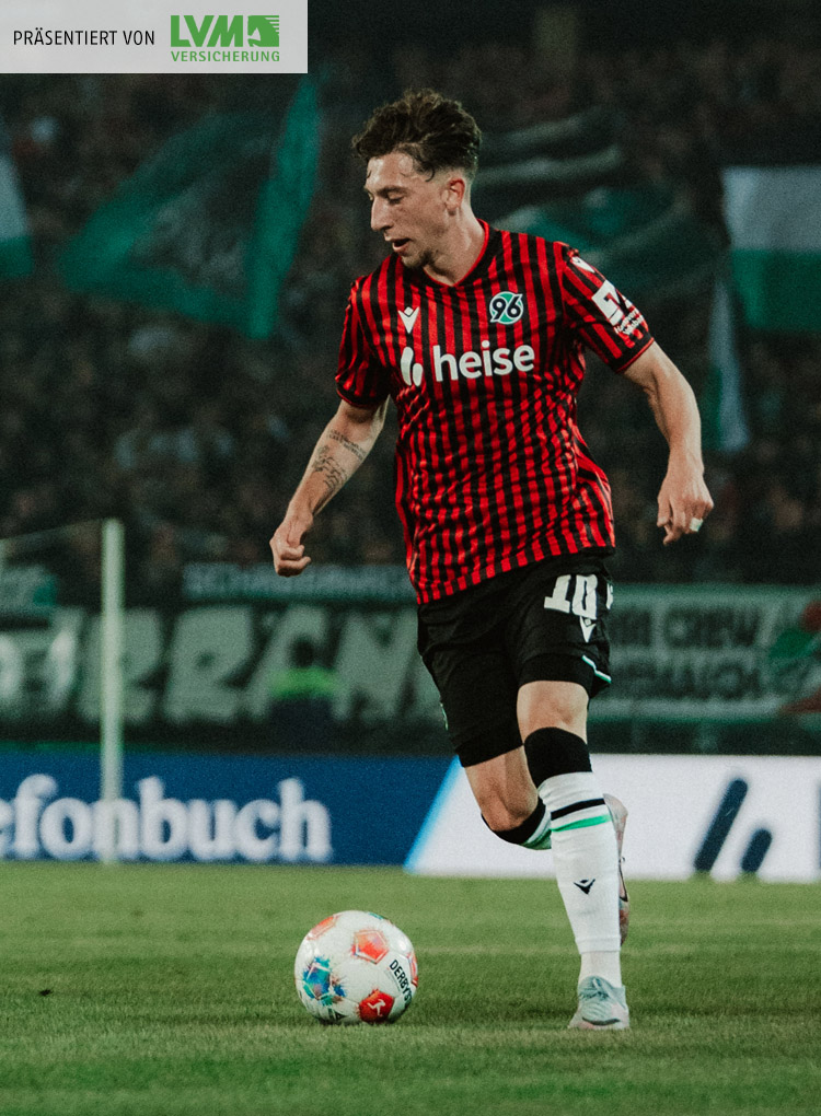 Jannik Rochelt ist am Ball, im Hintergrund unscharf die volle Nordkurve.