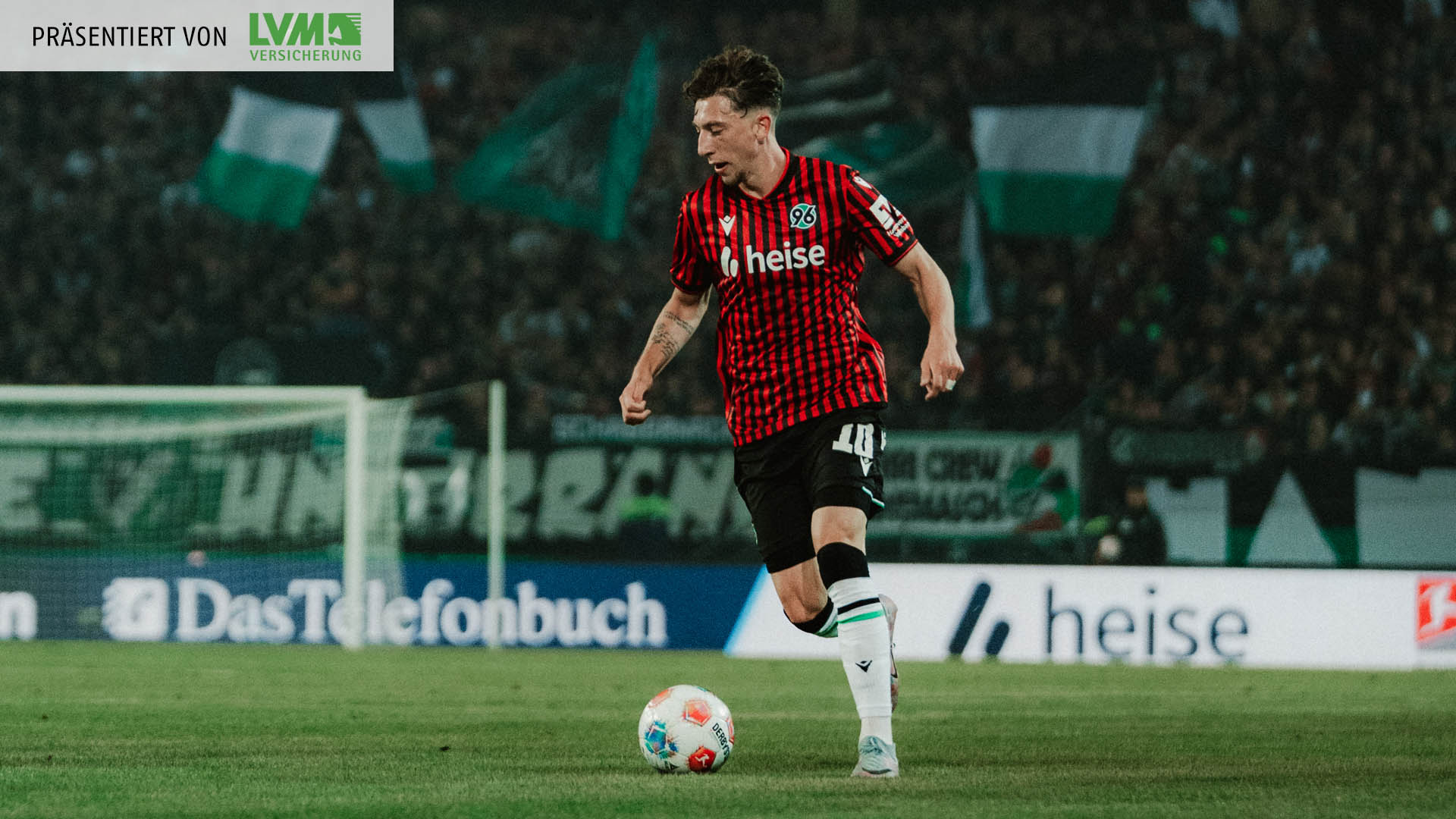 Jannik Rochelt ist am Ball, im Hintergrund unscharf die volle Nordkurve.