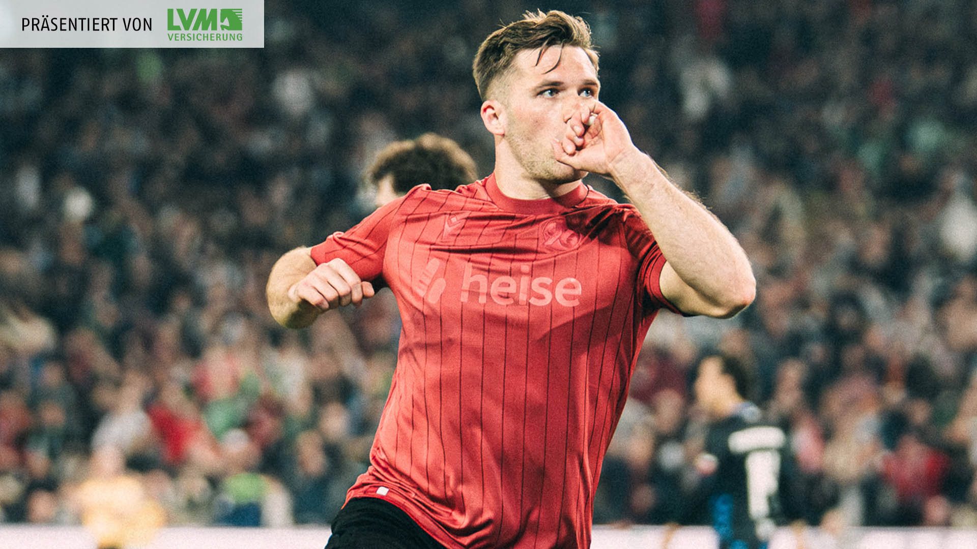 Benjamin Källman jubelt im Jubiläumstrikot und küsst dabei seinen linken Handrücken. 