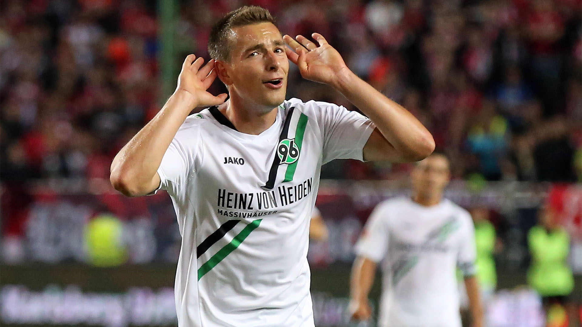 Artur Sobiech jubelt nach einem Tor, schaut in Richtung der Hannover-96-Fans und hält die Hände an beide Ohren.