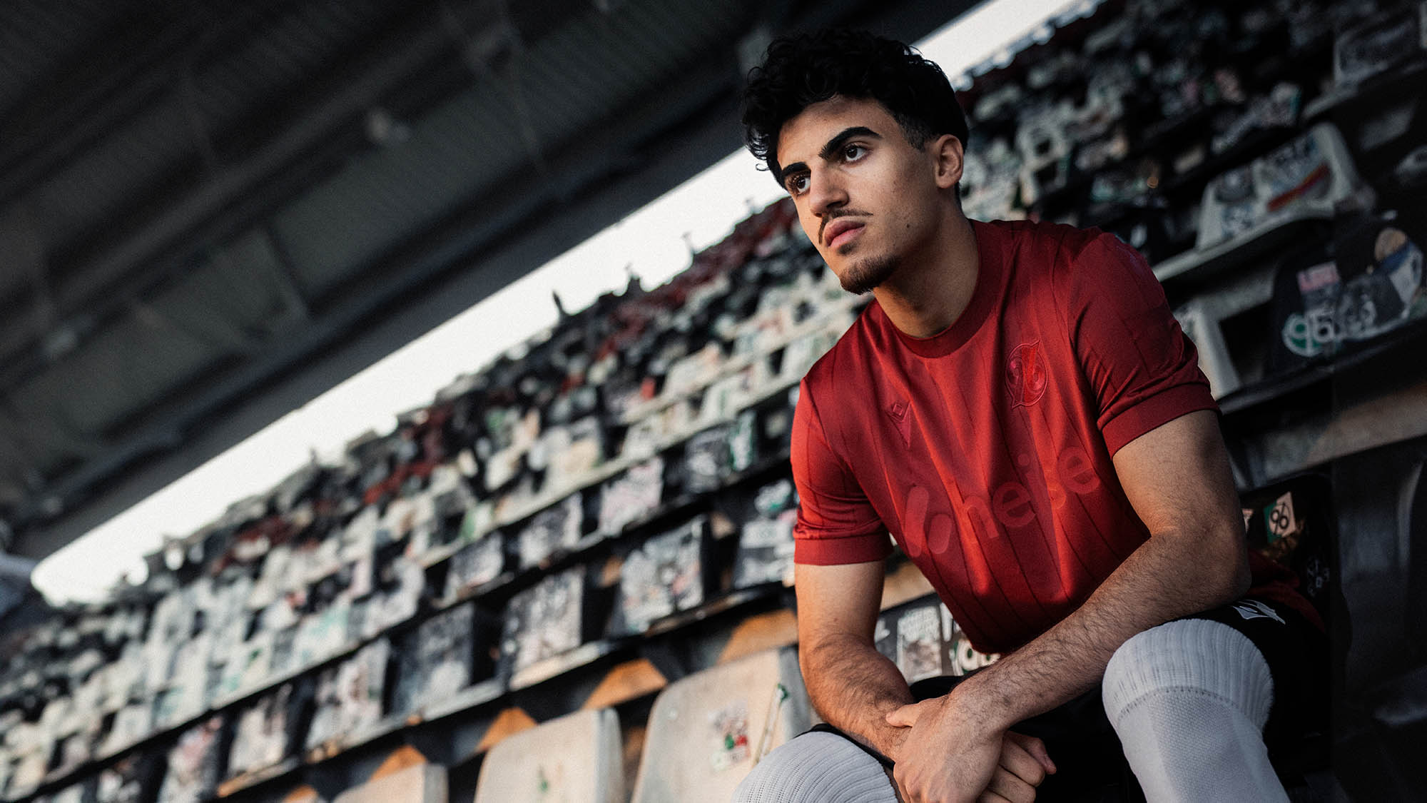 Husseyn Chakroun sitzt im Sondertrikot auf der Tribüne.