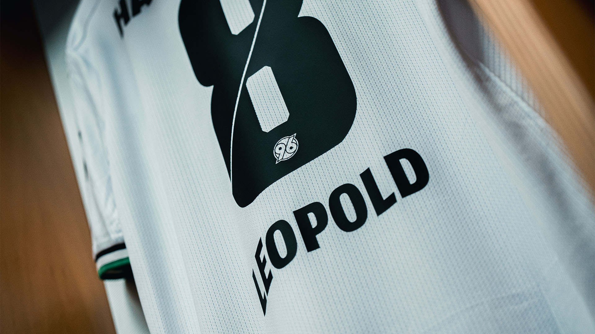 Ein weißes Trikot von Enzo Leopold hängt in der Kabine.