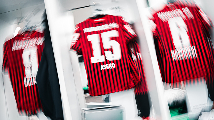 Drei Heimtrikots hängen in der Kabine.