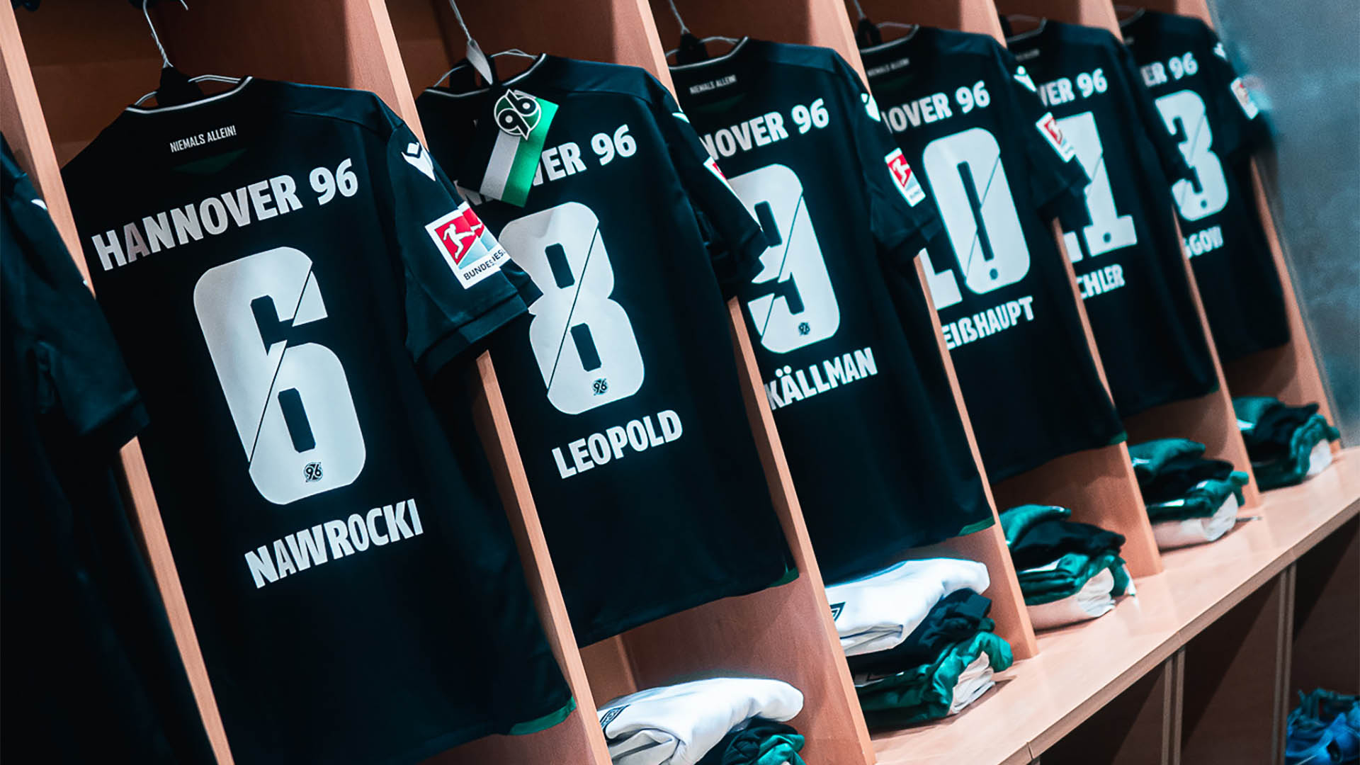 Die 96-Auswärtstrikots hängen aufgereiht in der Kabine.