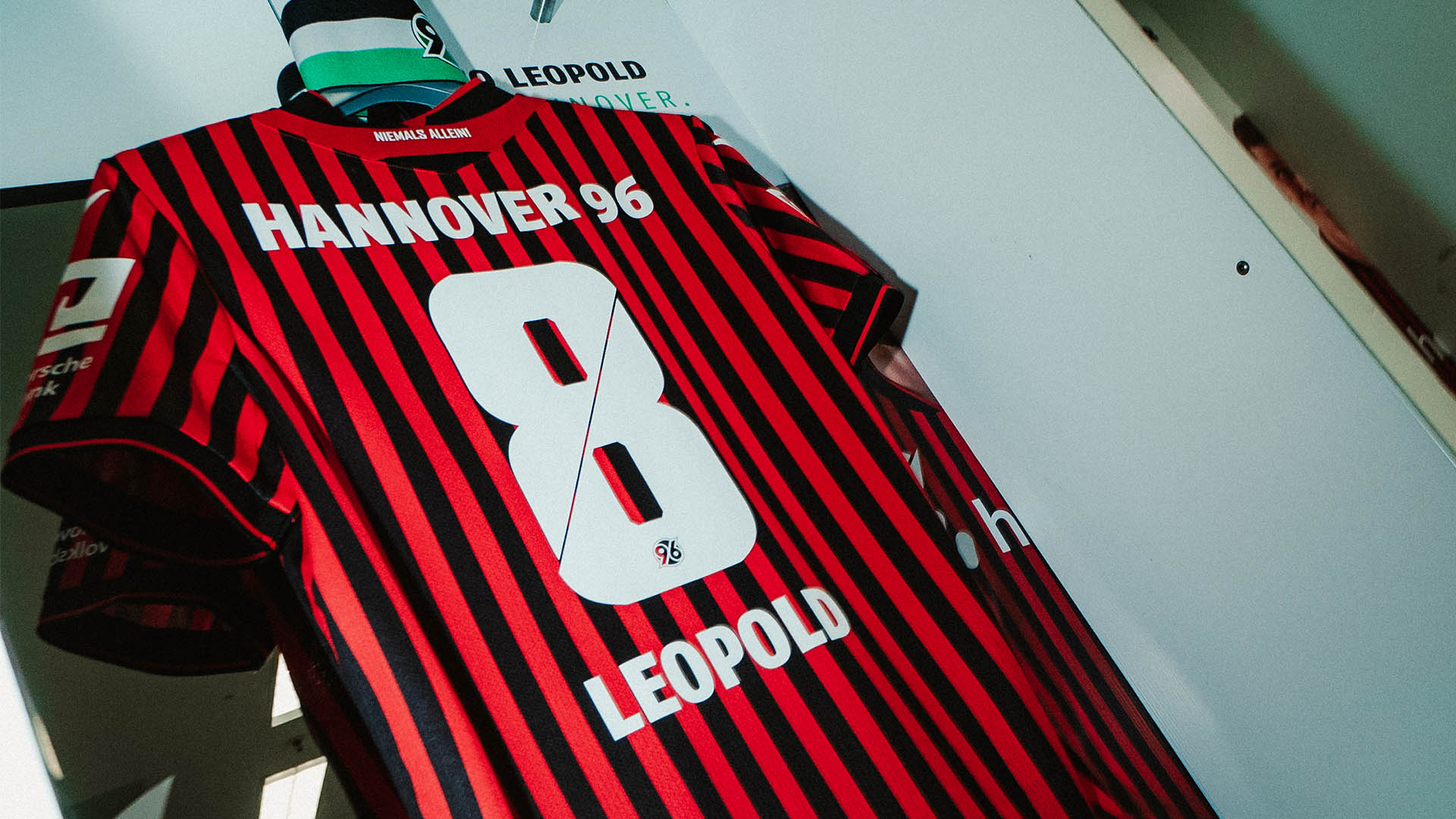 Das Heimtrikot von Enzo Leopold hängt mit der Kapitänsbinde in der Kabine.