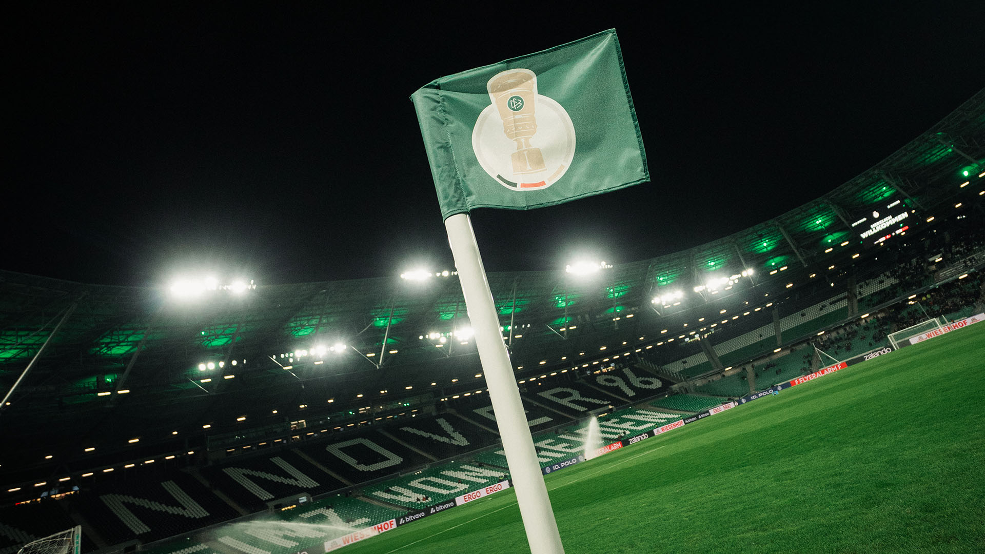 Die DFB-Pokal-Eckfahne vor dem hell erleuchteten 96-Stadion,