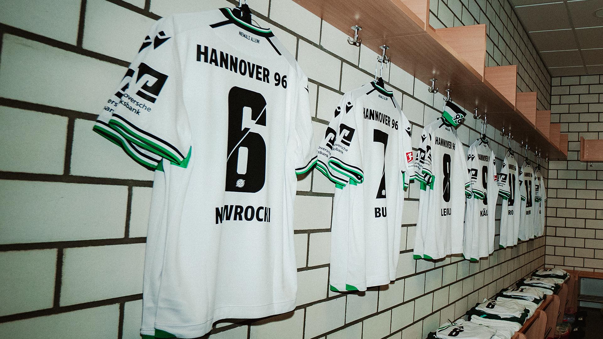 Die weißen 96-Trikots hängen aufgereiht in der Kabine.