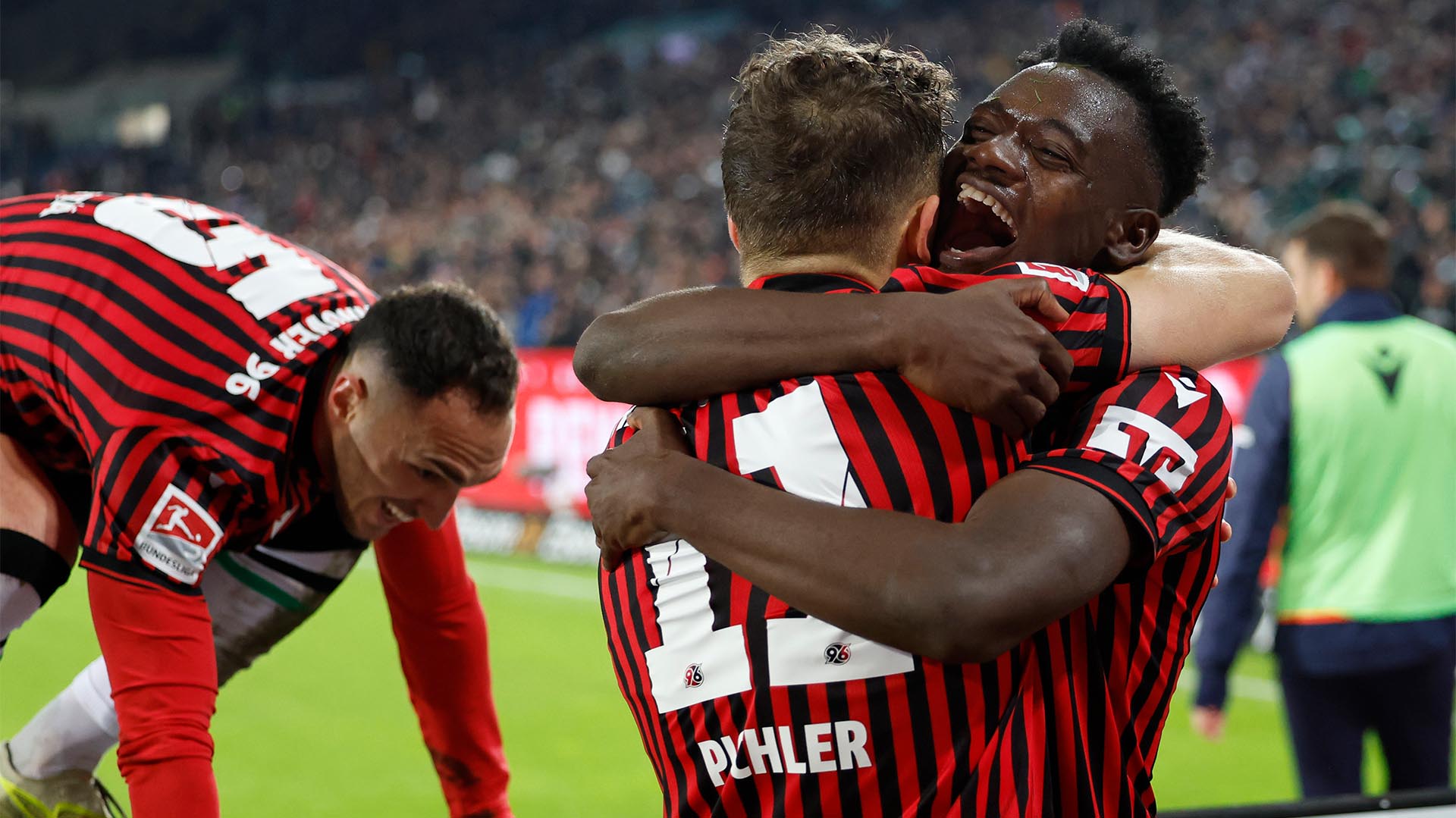 Benedikt Pichler und Mustapha Bundu umarmen sich jubelnd, im Hintergrund steigt Virgil Ghita auf die Bande.