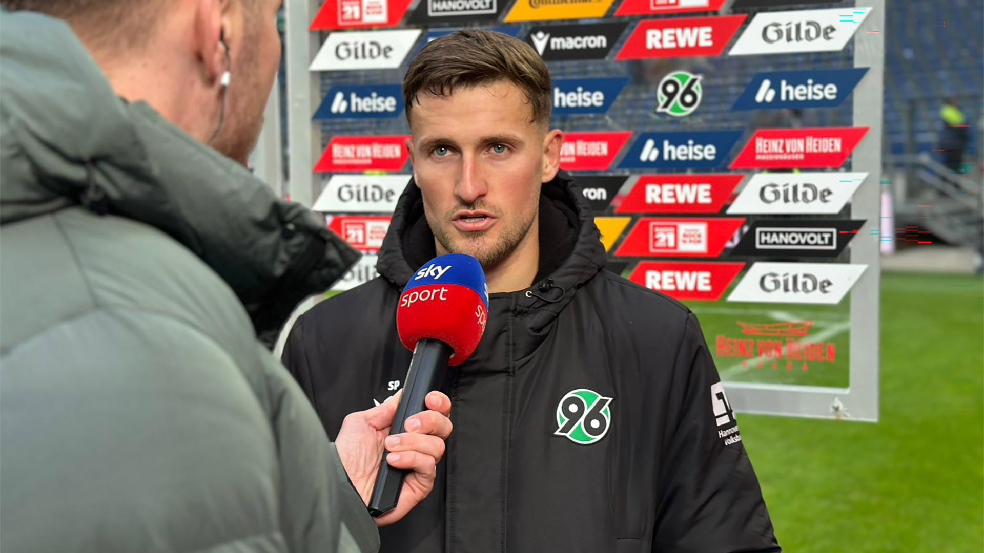 Enzo Leopold vor einer Sponsorenwand am Sky-Mikrofon.