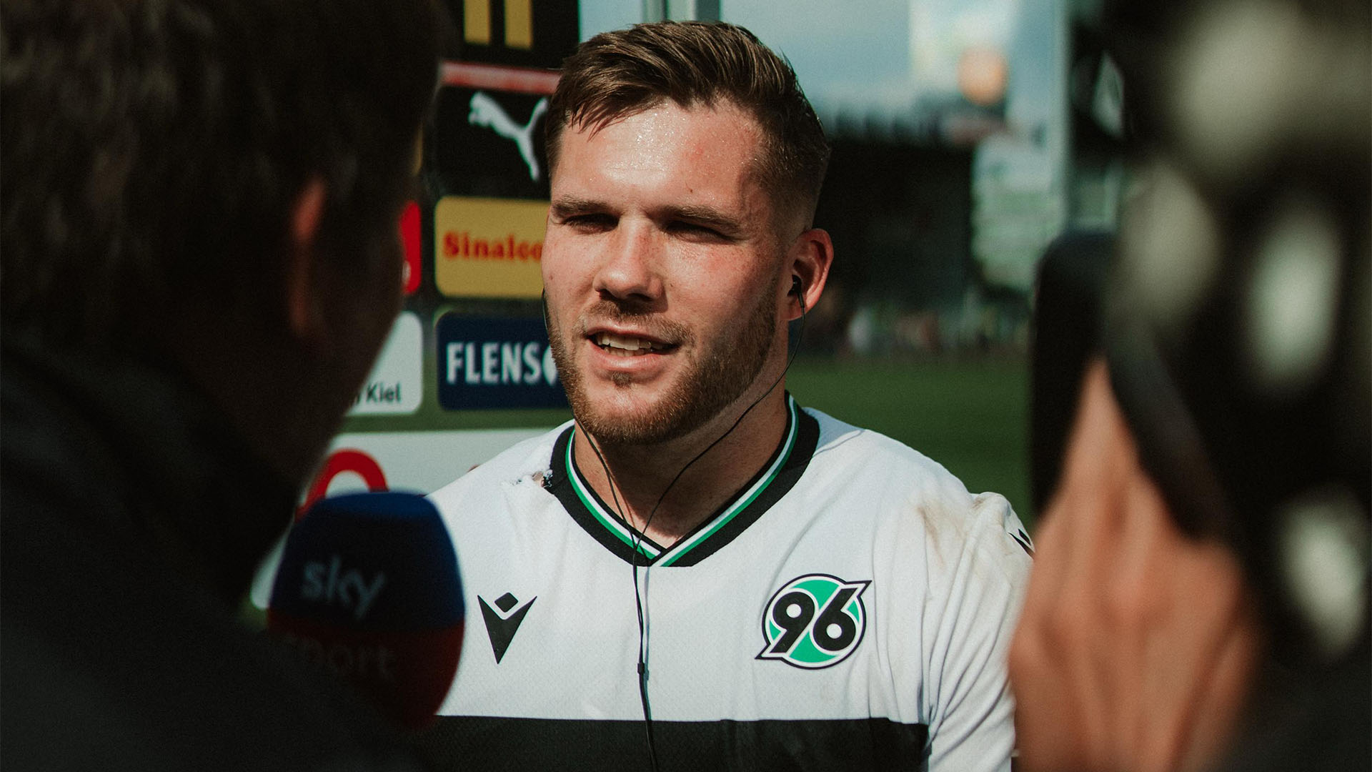 Benjamin Källman spricht lächelnd am Mikro.