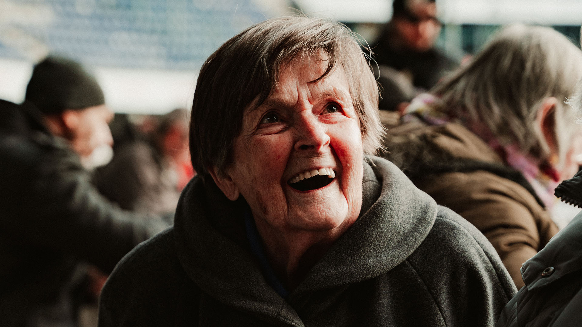 Annemarie Streit sitzt an einem Tisch und lacht.