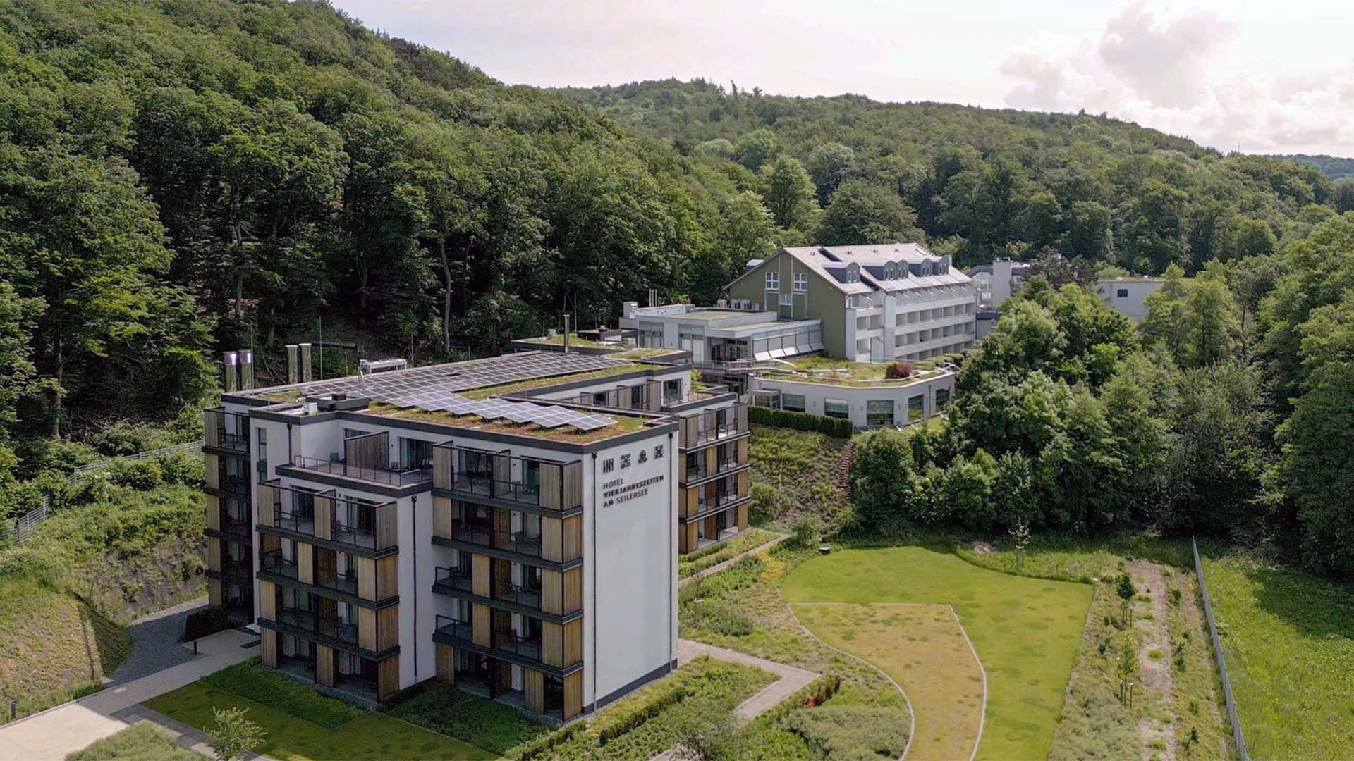 Blick auf ein Hotel bestehend aus mehreren Gebäuden, außen herum ist Wald.