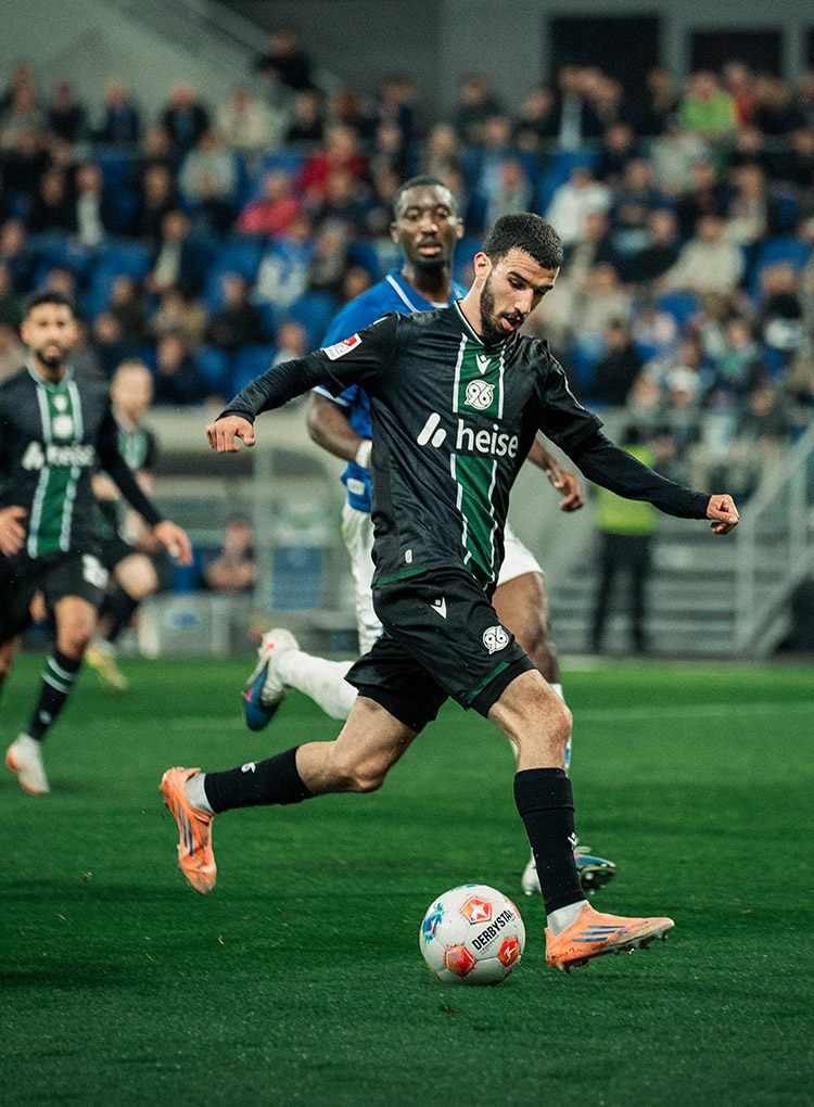 Waniss Taibi im schwarzen Auswärtstrikot im Laufen am Ball.