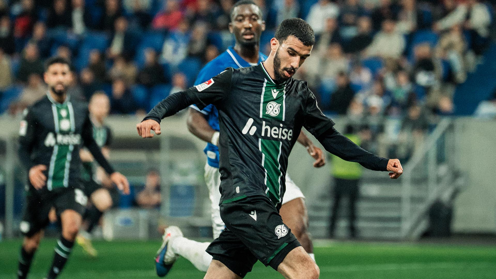 Waniss Taibi im schwarzen Auswärtstrikot im Laufen am Ball.