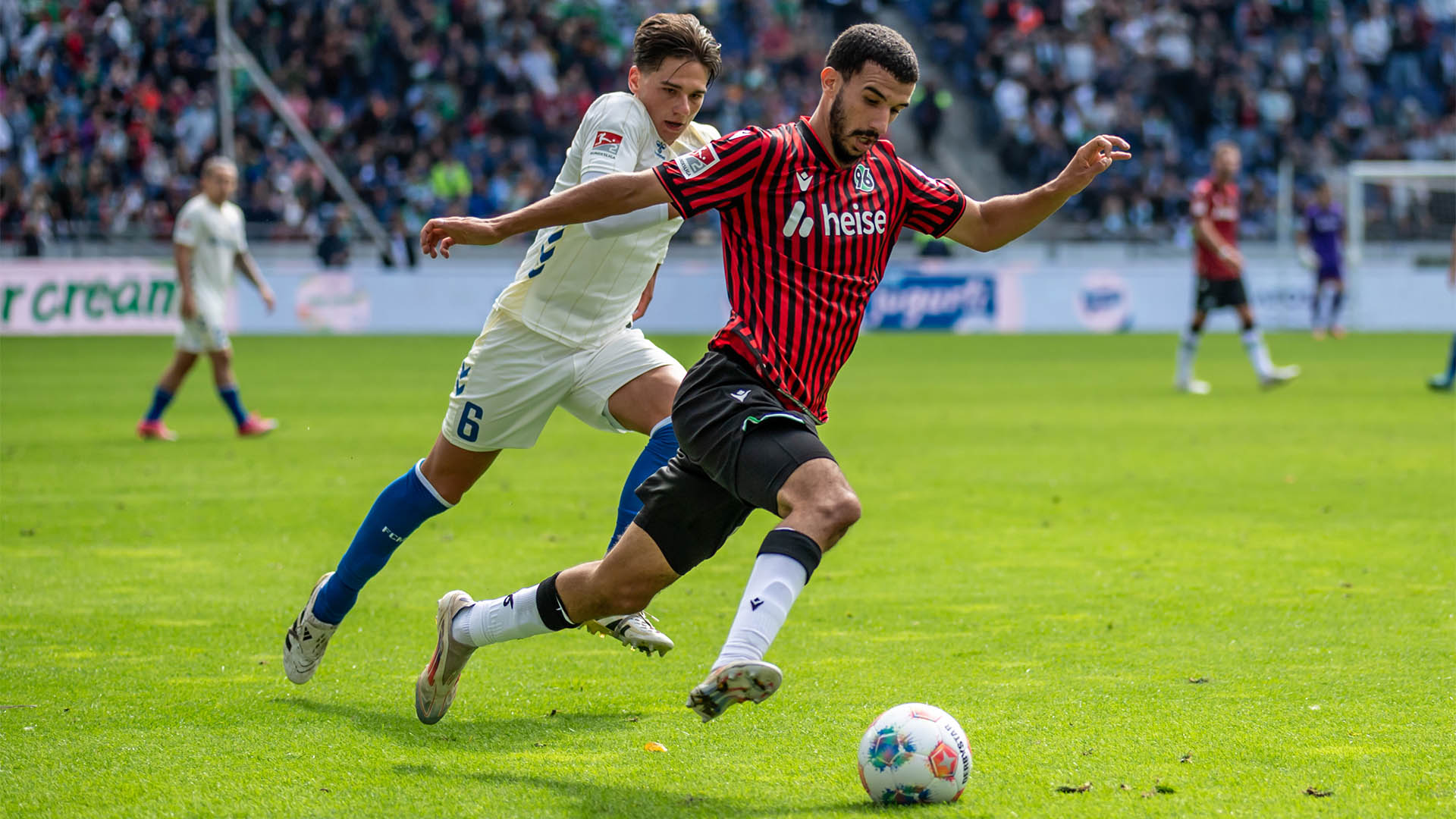 Waniss Taibi im Laufduell mit Magdeburgs Dariusz Stalmach, Taibi ist vorne und am Ball. 
