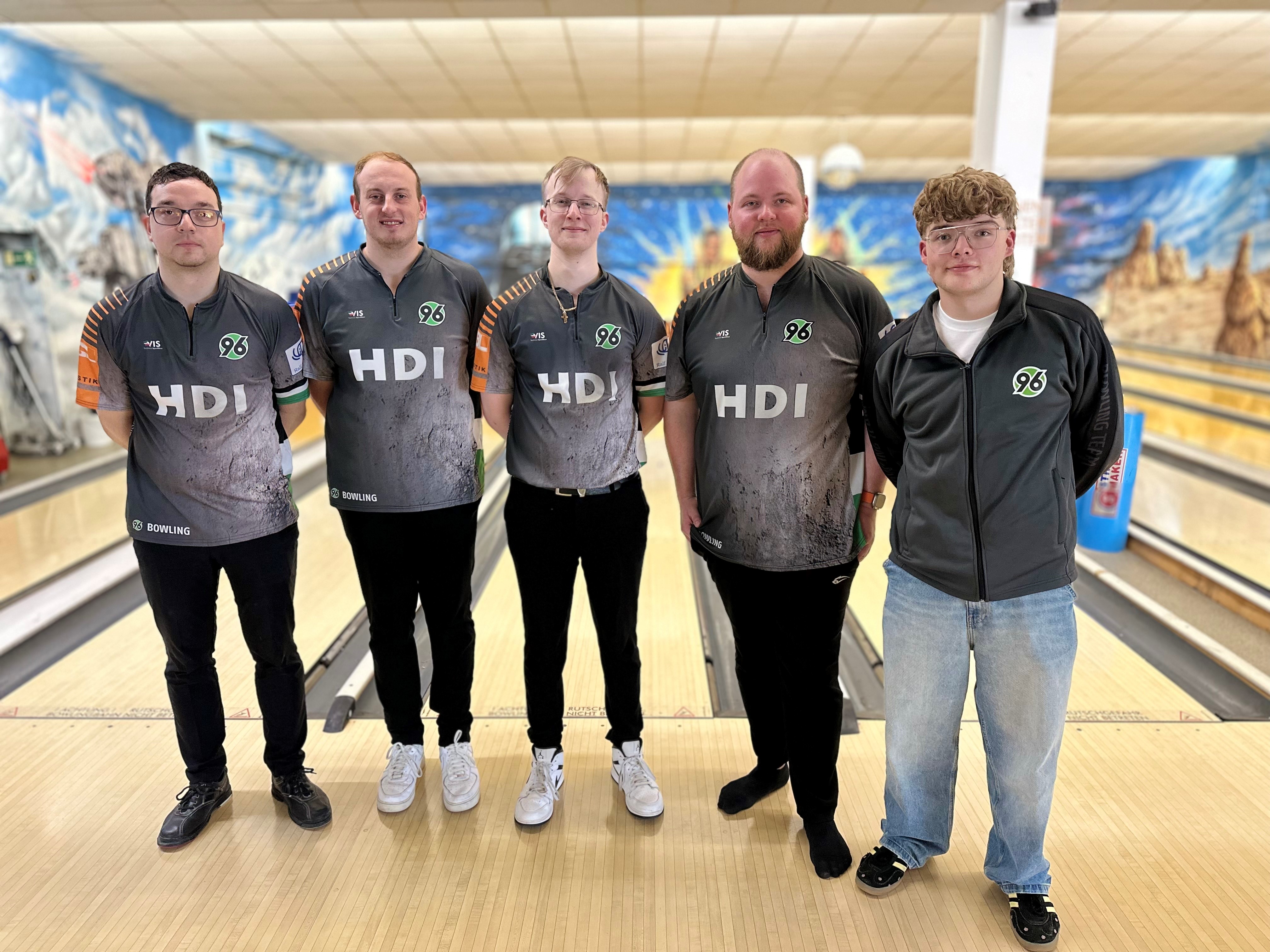 Das Team der ersten Herren, steht mit armen auf dem Rücken vor den Bowlingbahnen.