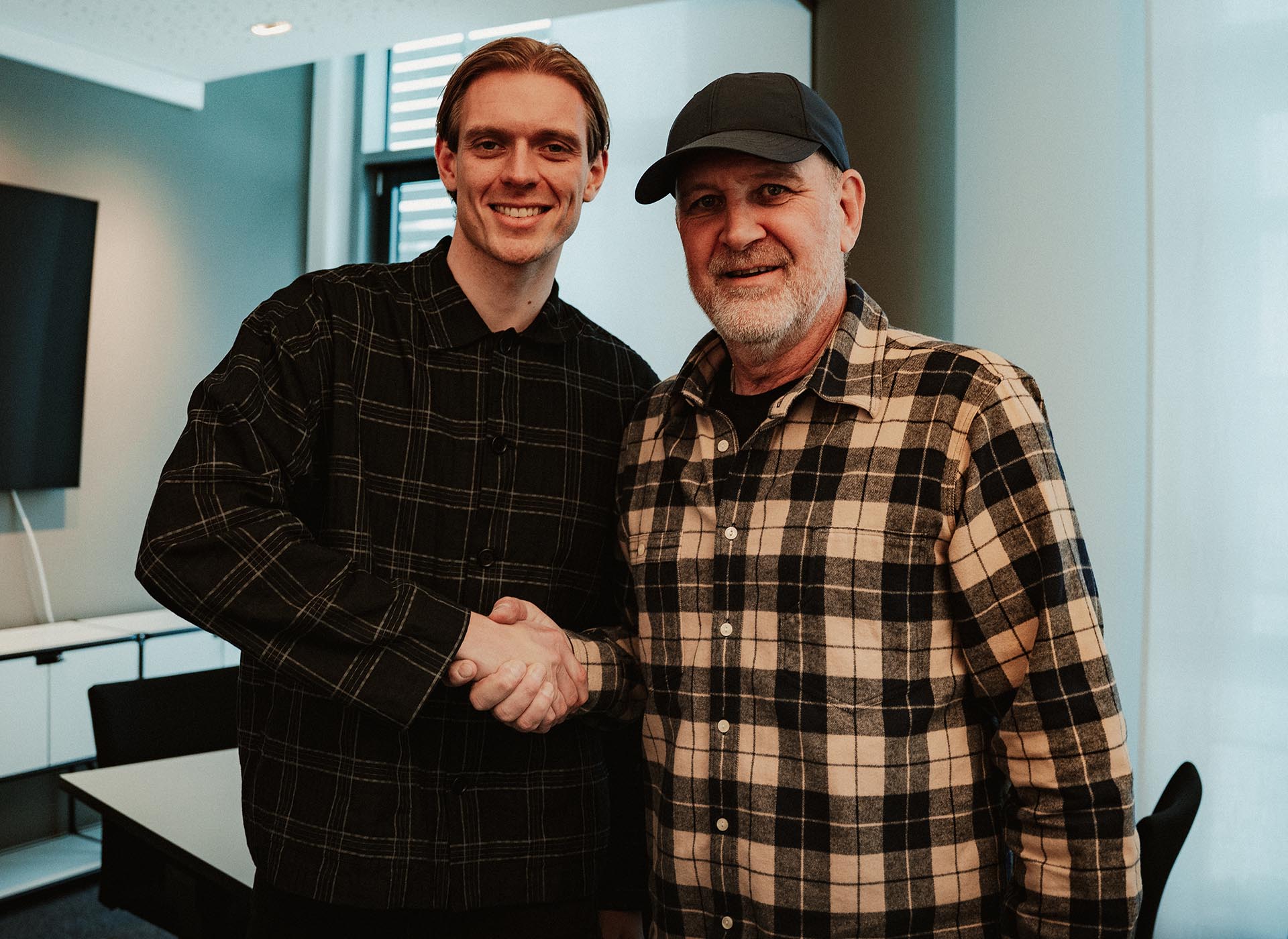 Stefan Teitur Thordarson und Jörg Schmadtke beim Handshake im Büro.