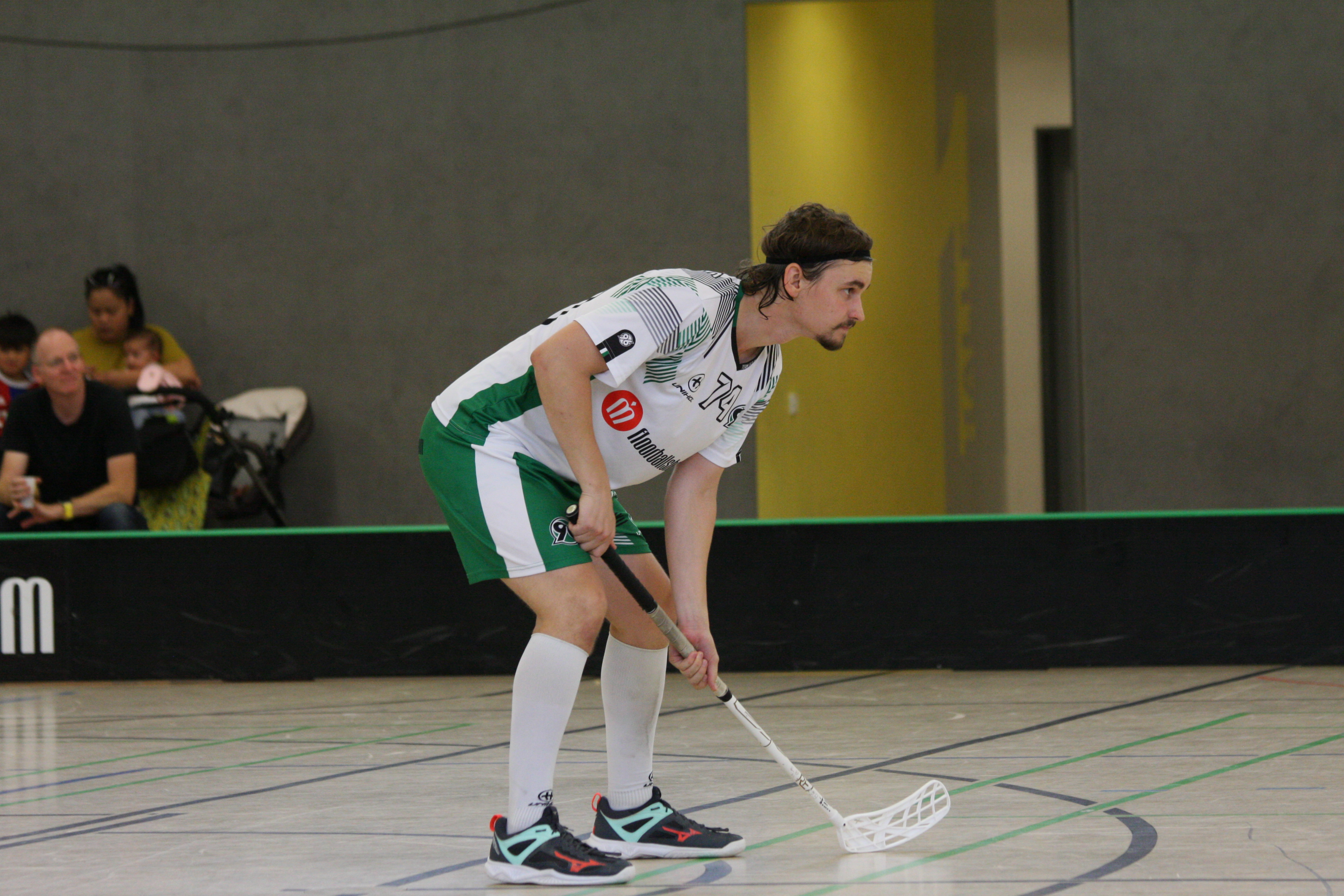Tim Brömer hält den Floorballschläger in Spielkleidung mit beiden Händen fest.