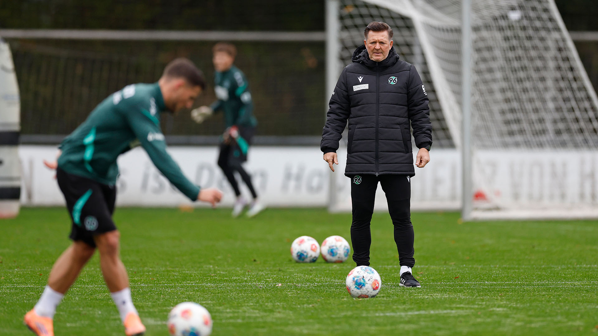 Christian Titz im Training mit einem Ball vor sich.