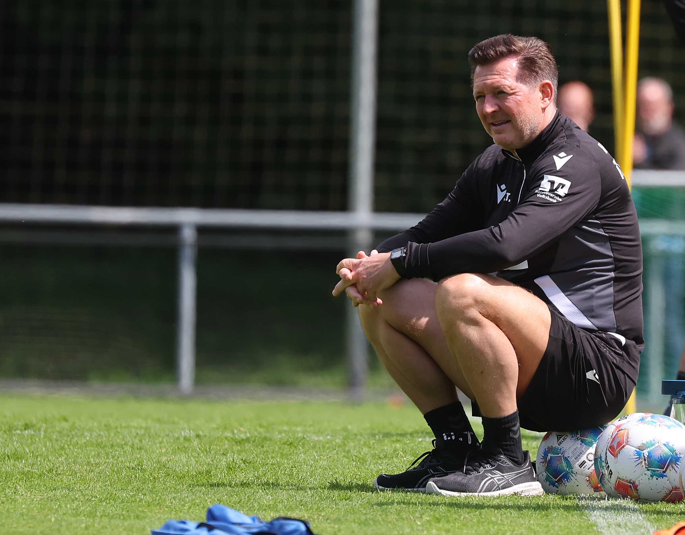 Christian Titz sitzt auf dem Trainingsplatz auf einem Ball.