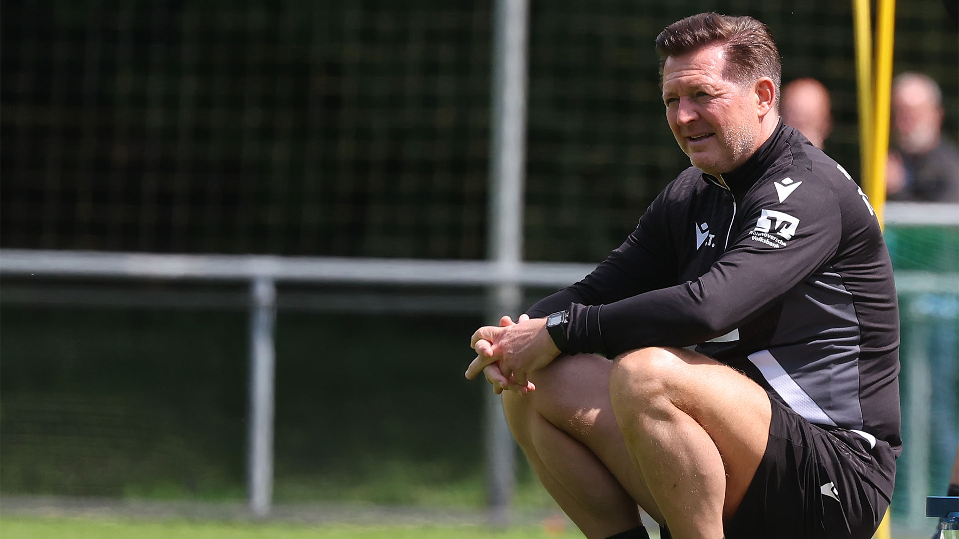Christian Titz sitzt auf dem Trainingsplatz auf einem Ball.