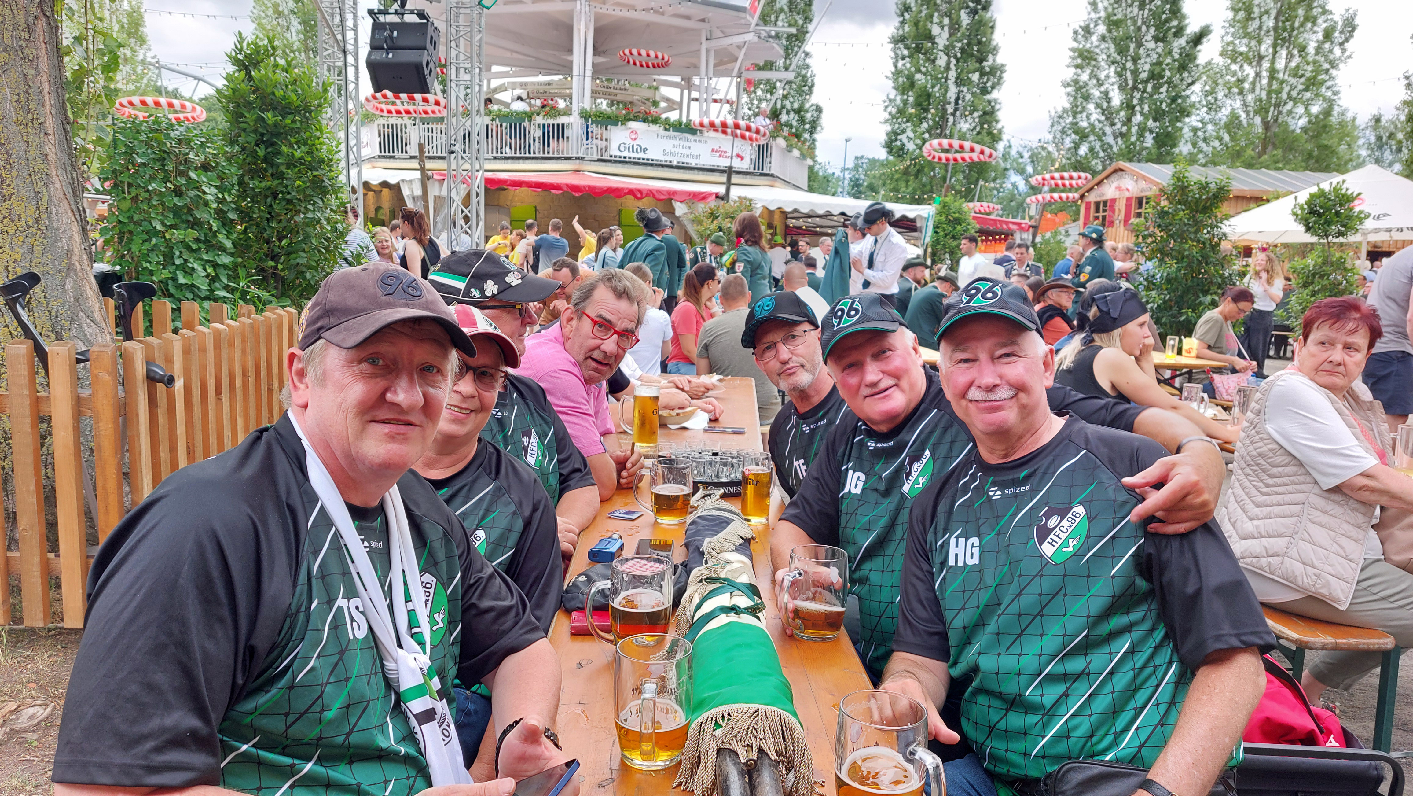 Vier Mitglieder der Abteilung Tradition sitzen an einer Bierzeltgarnitur.
