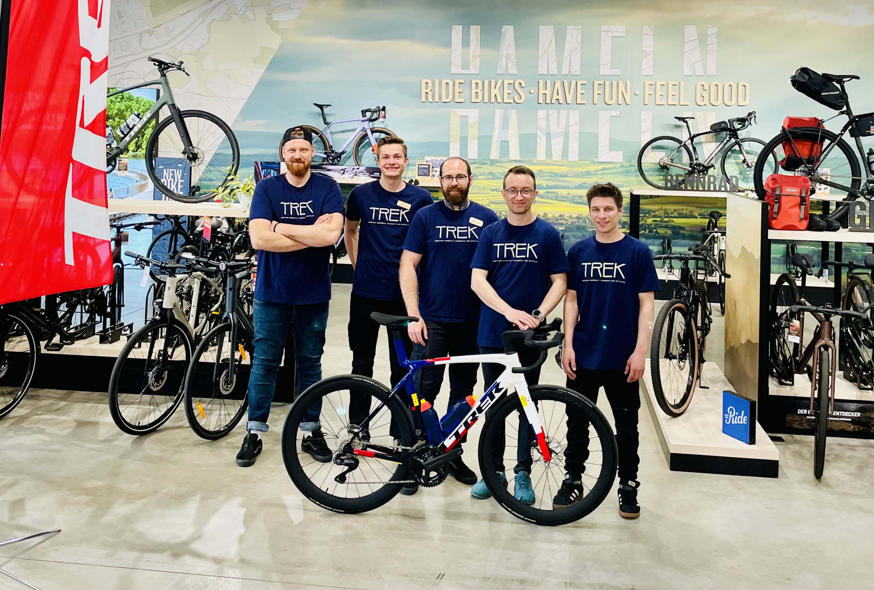 Die Mitarbeiter vom neuen Partner posieren hinter einem Fahrrad.